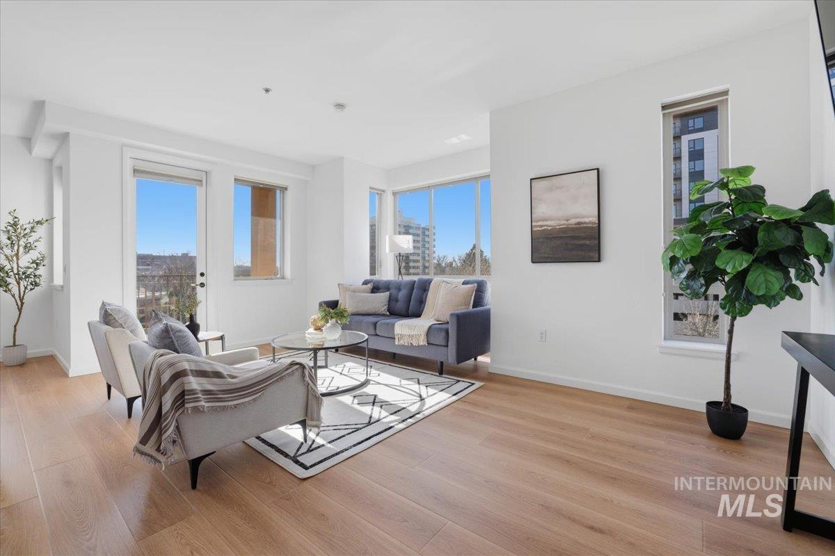 Living area with light wood-style flooring and healthy amount of natural light