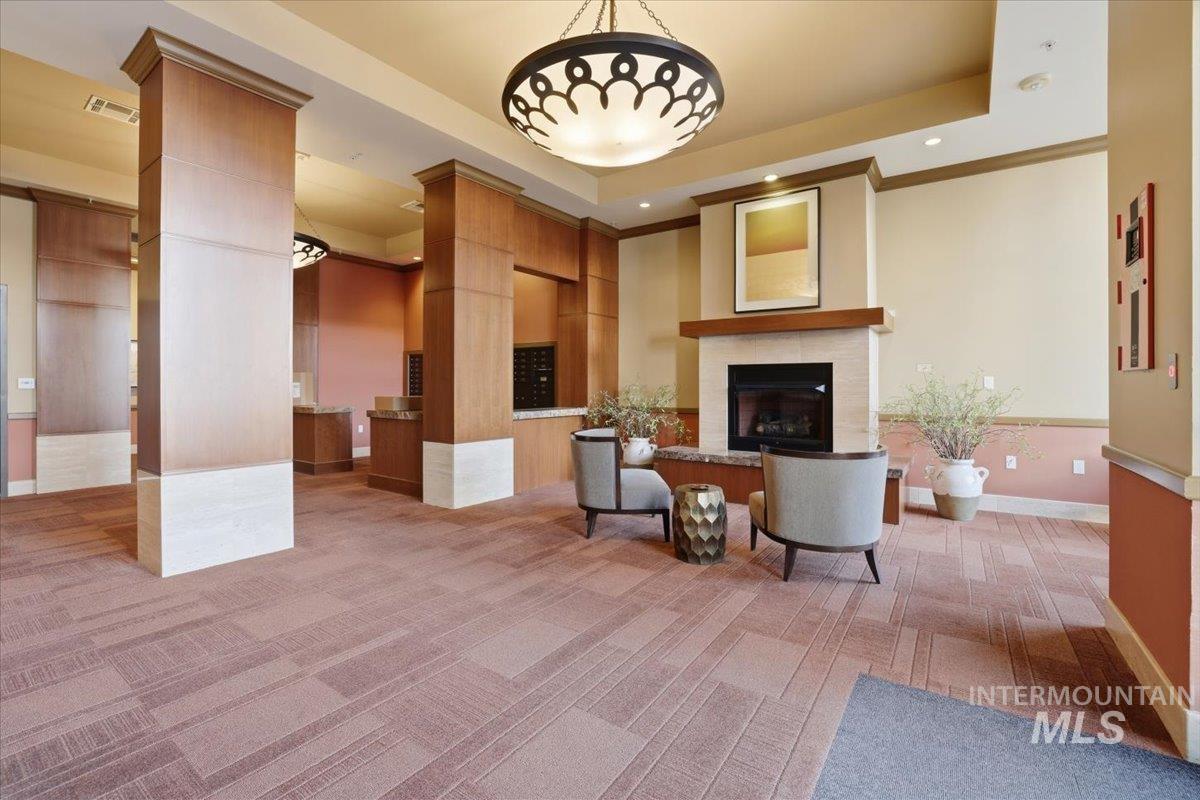 Living room featuring light colored carpet, recessed lighting, a tile fireplace, and a raised ceiling