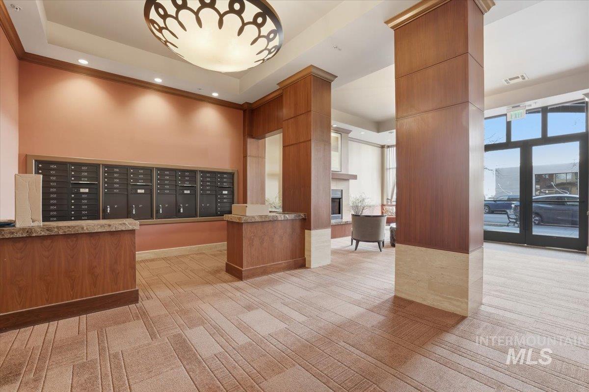 View of property's community featuring a high tray ceiling, recessed lighting, mail area, and a large fireplace