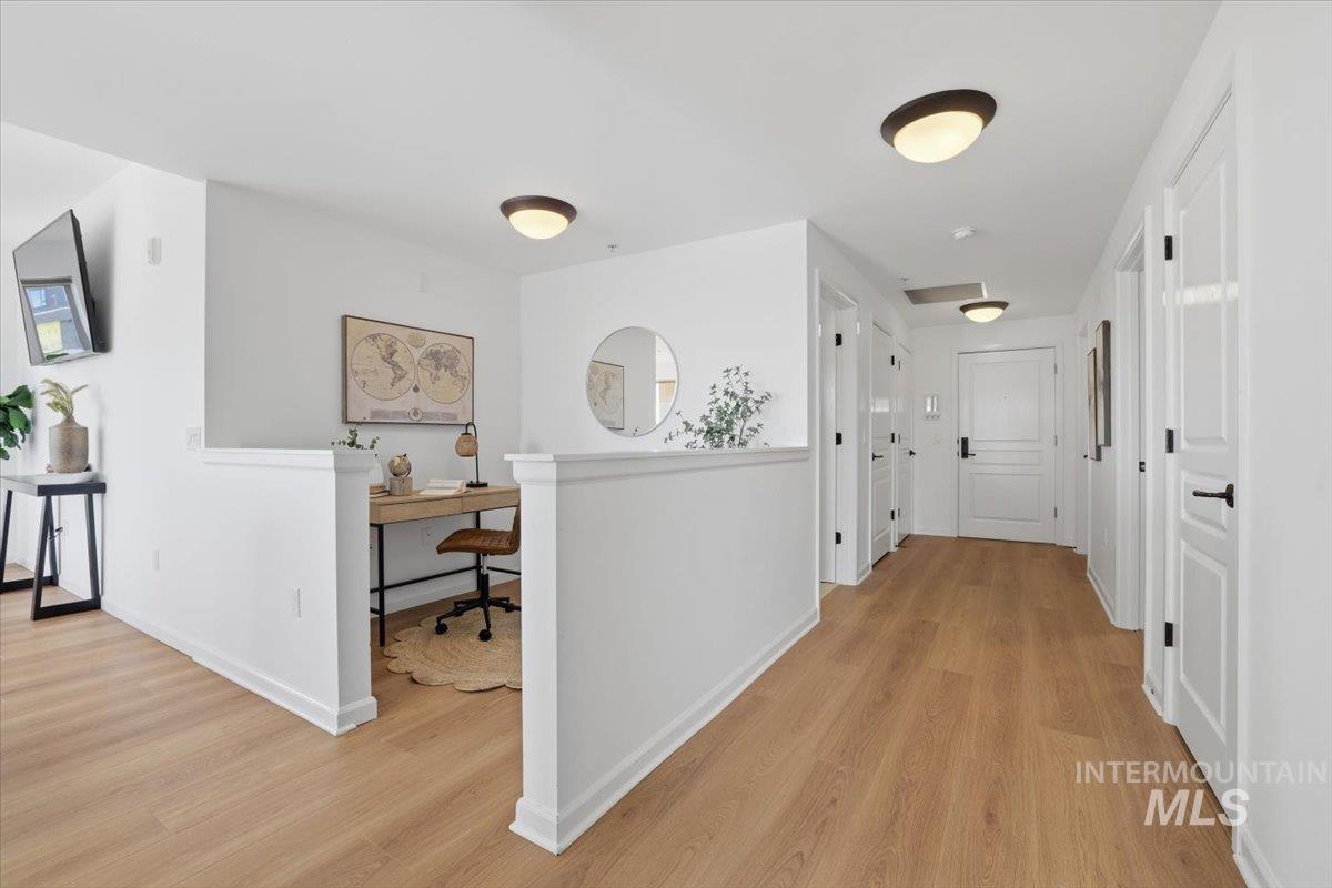 Hall with light wood finished floors and an office area