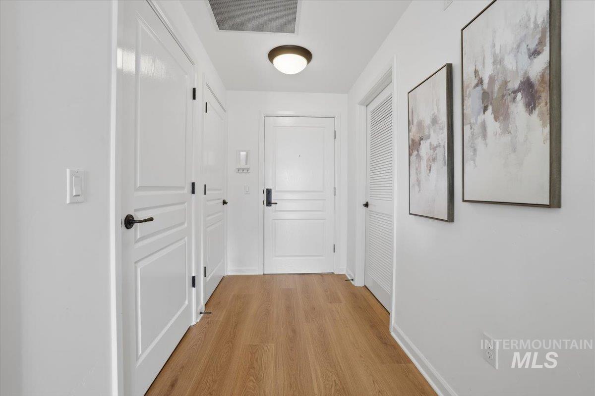 Corridor featuring light wood-type flooring and baseboards