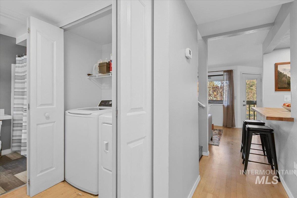 Laundry area featuring light wood finished floors and independent washer and dryer