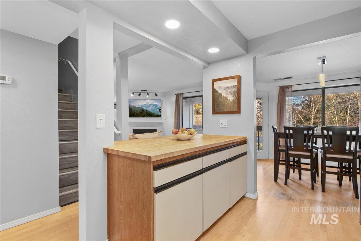 Kitchen with wooden counters, light wood-type flooring, recessed lighting, and white cabinets