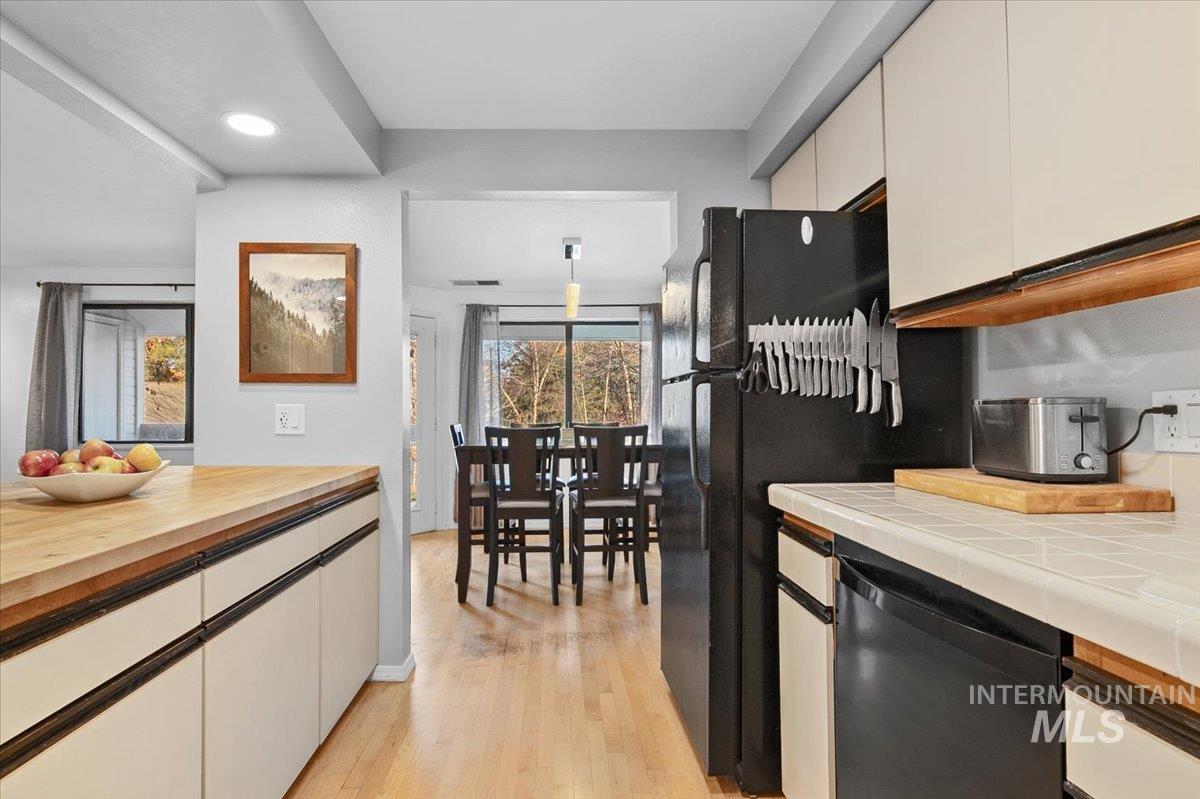 Kitchen featuring black appliances, light wood-style flooring, and recessed lighting