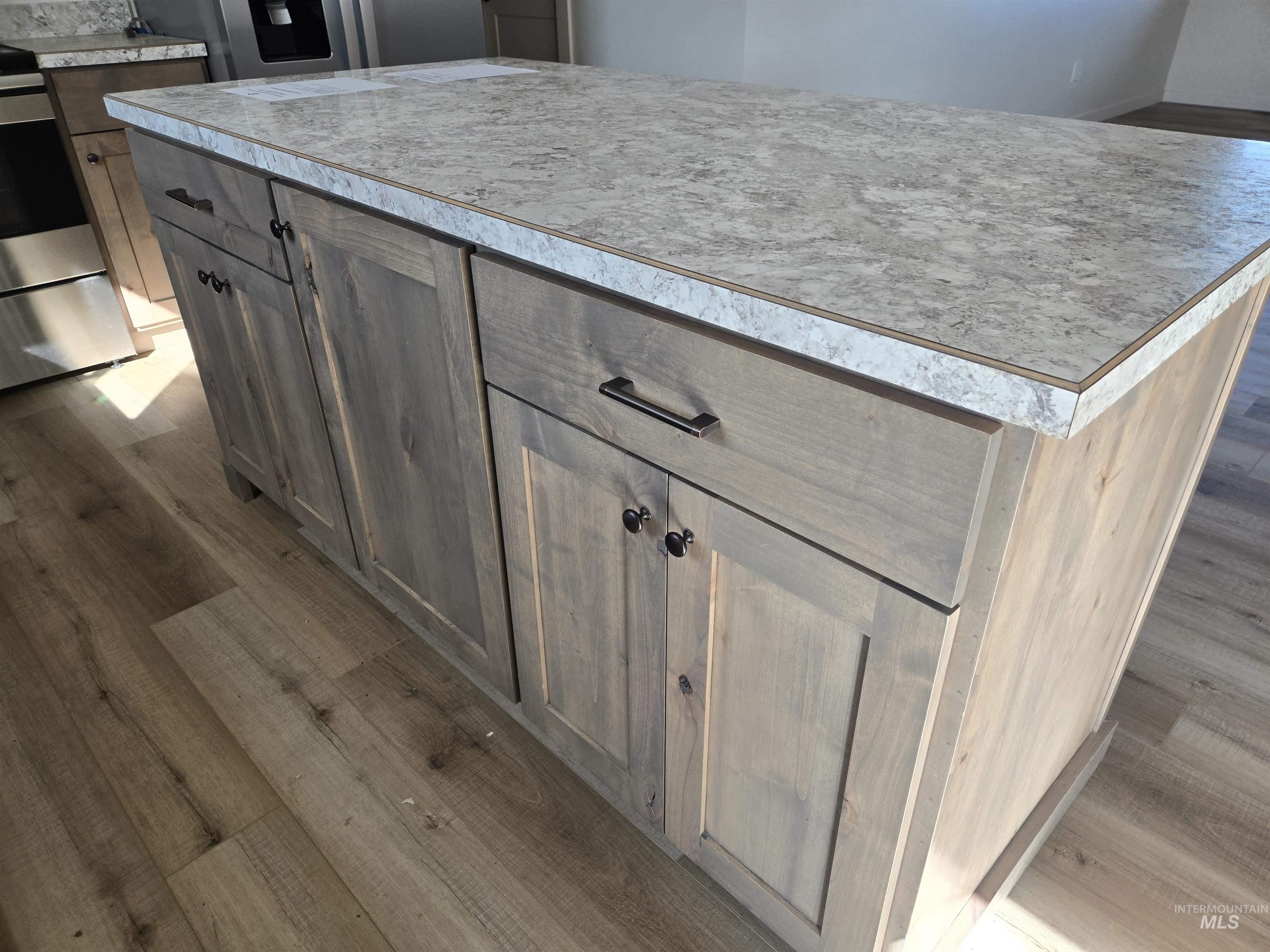 Kitchen view of dark wood finished floors, electric stove, and light countertops