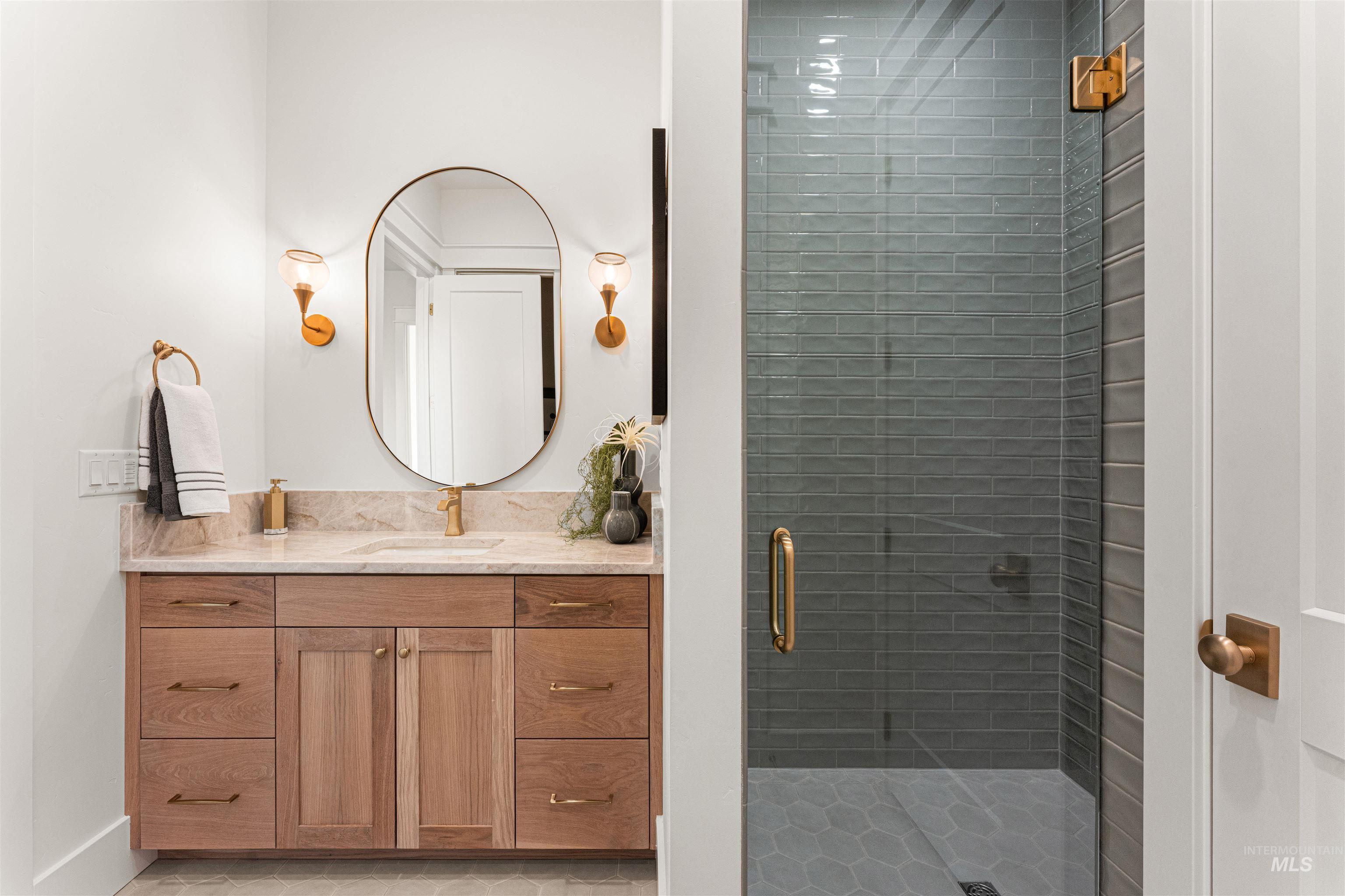 Bathroom featuring vanity, a stall shower, and light tile patterned floors