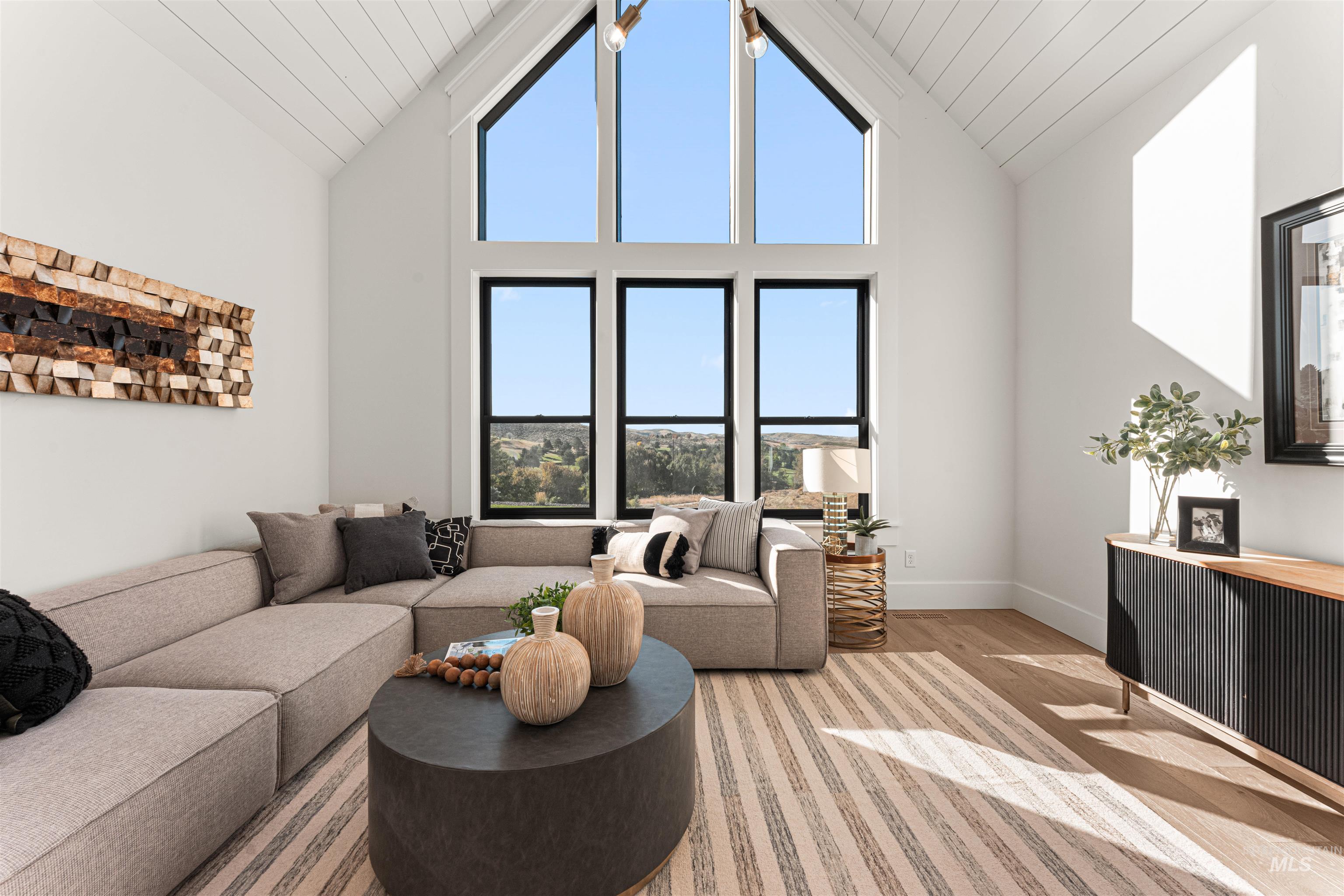 Living area featuring high vaulted ceiling and wood finished floors