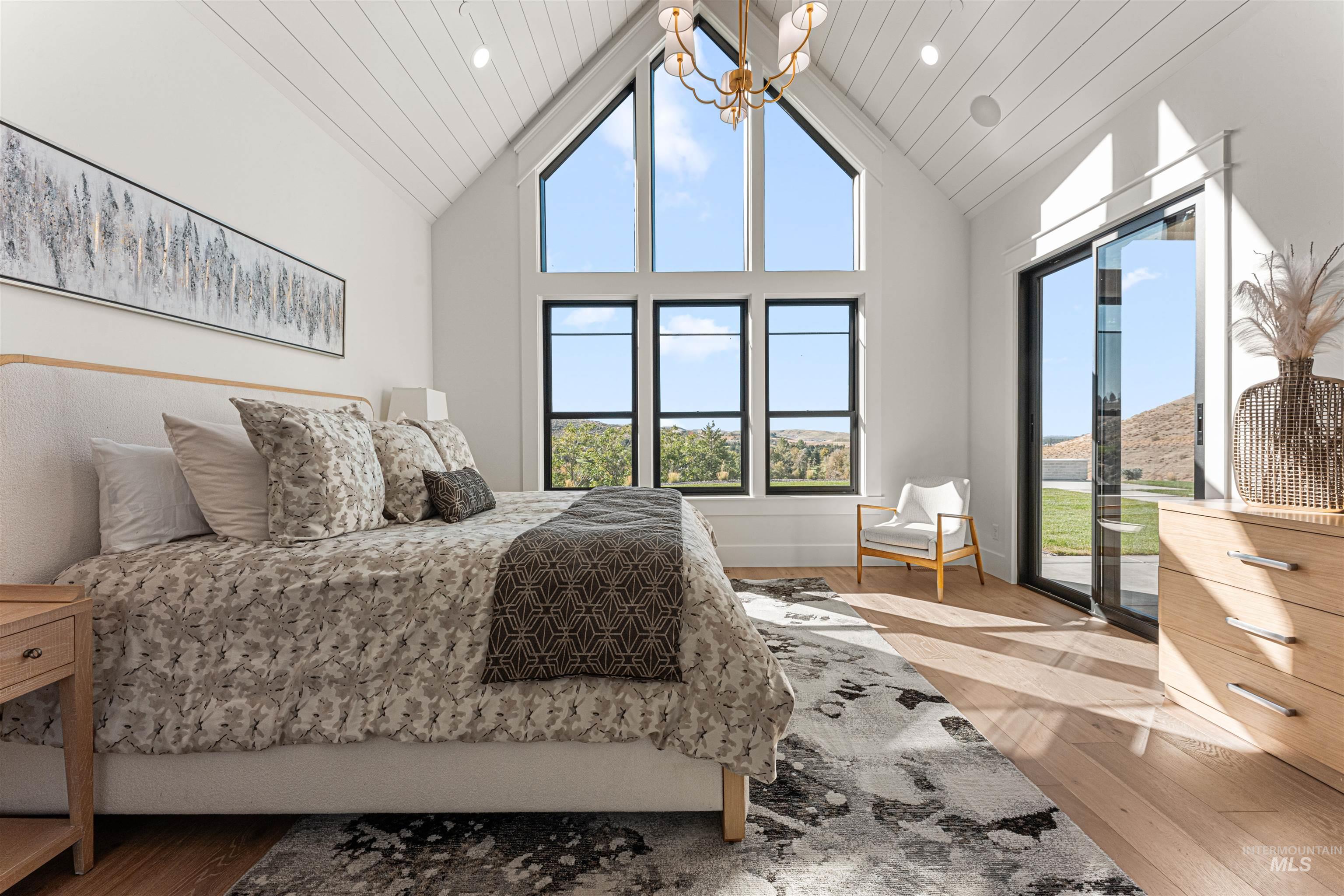 Bedroom with wood finished floors, high vaulted ceiling, multiple windows, access to exterior, and wooden ceiling