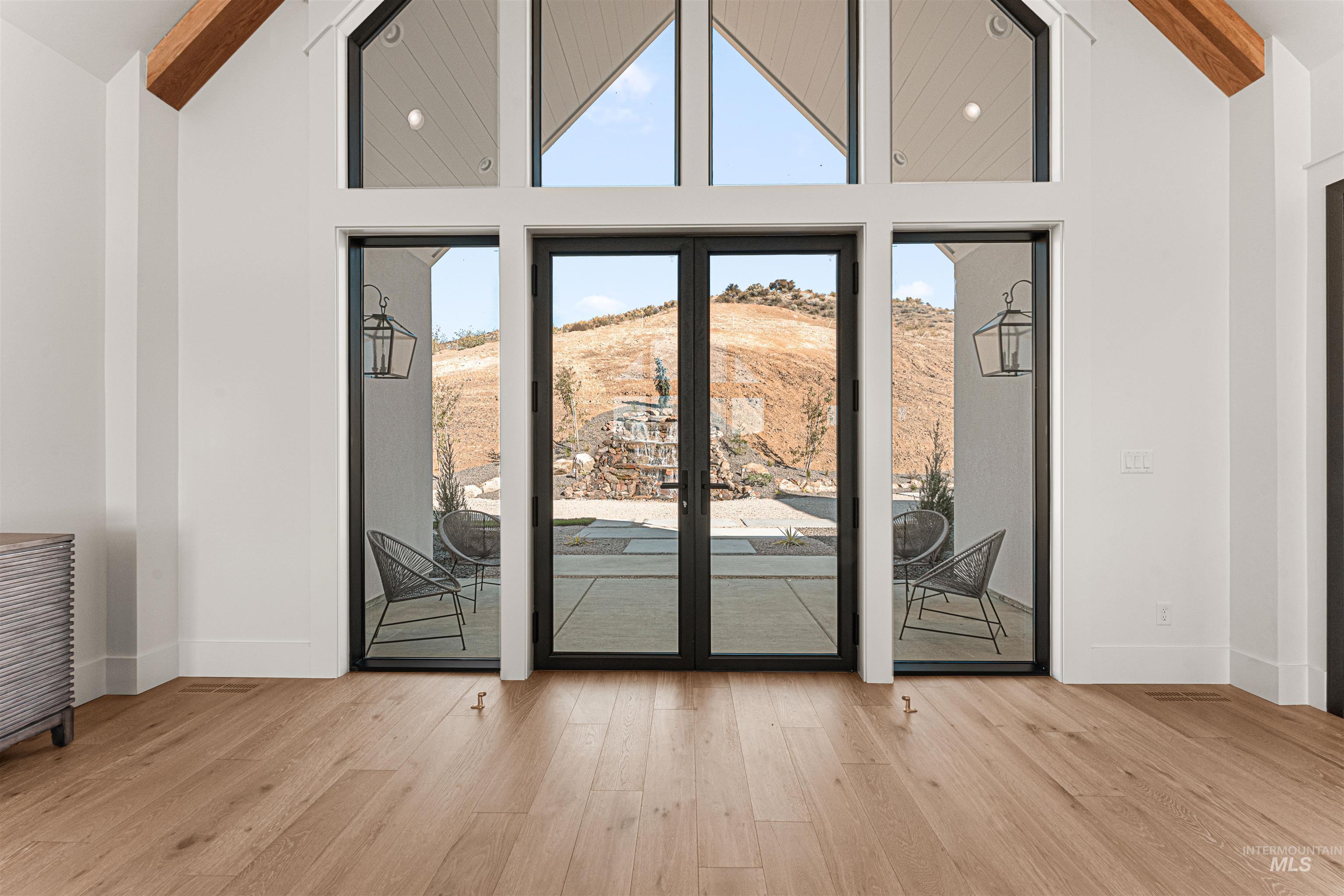 Entryway with high vaulted ceiling, wood finished floors, and beamed ceiling