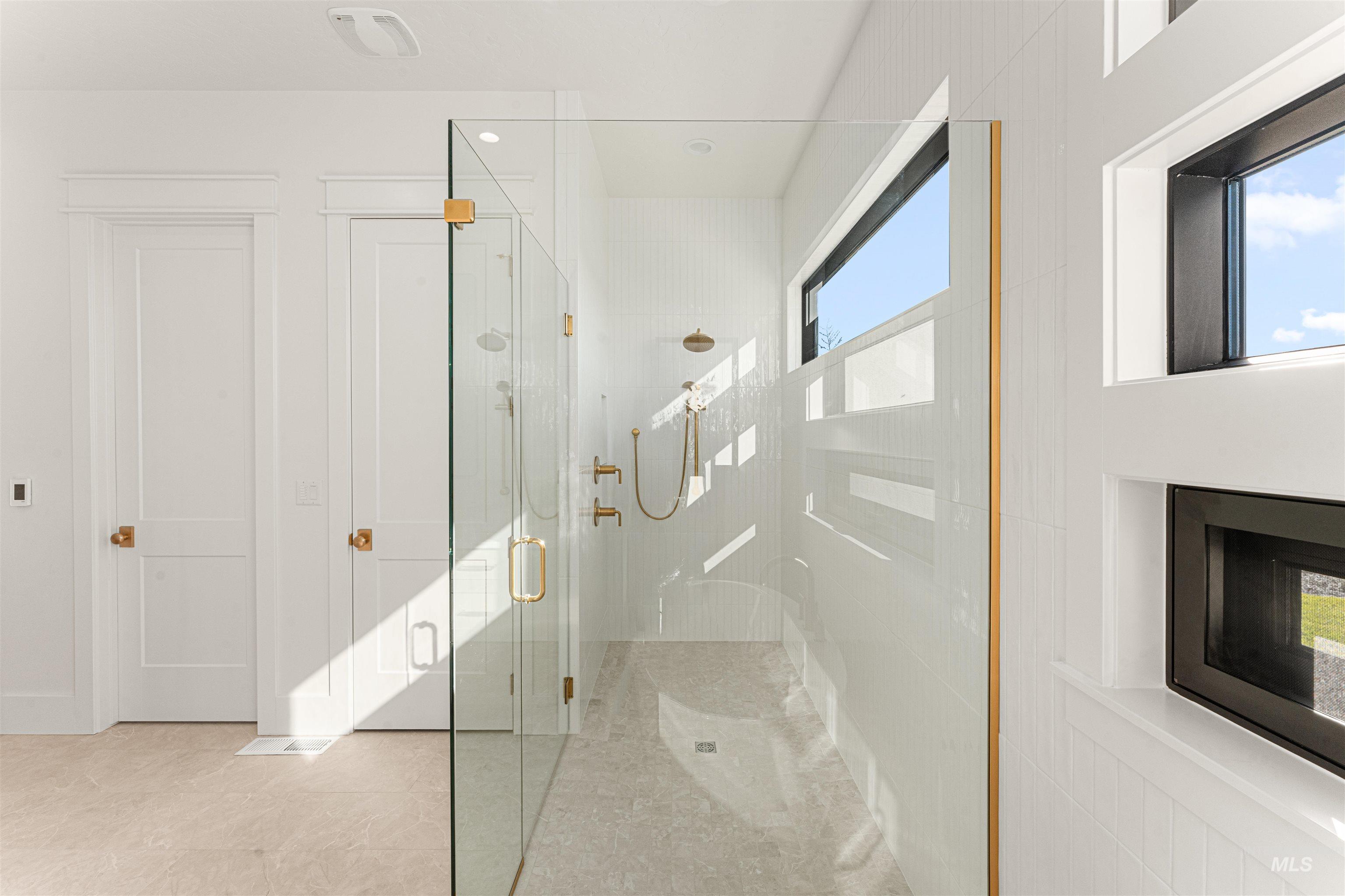 Bathroom featuring a shower stall and light tile patterned floors