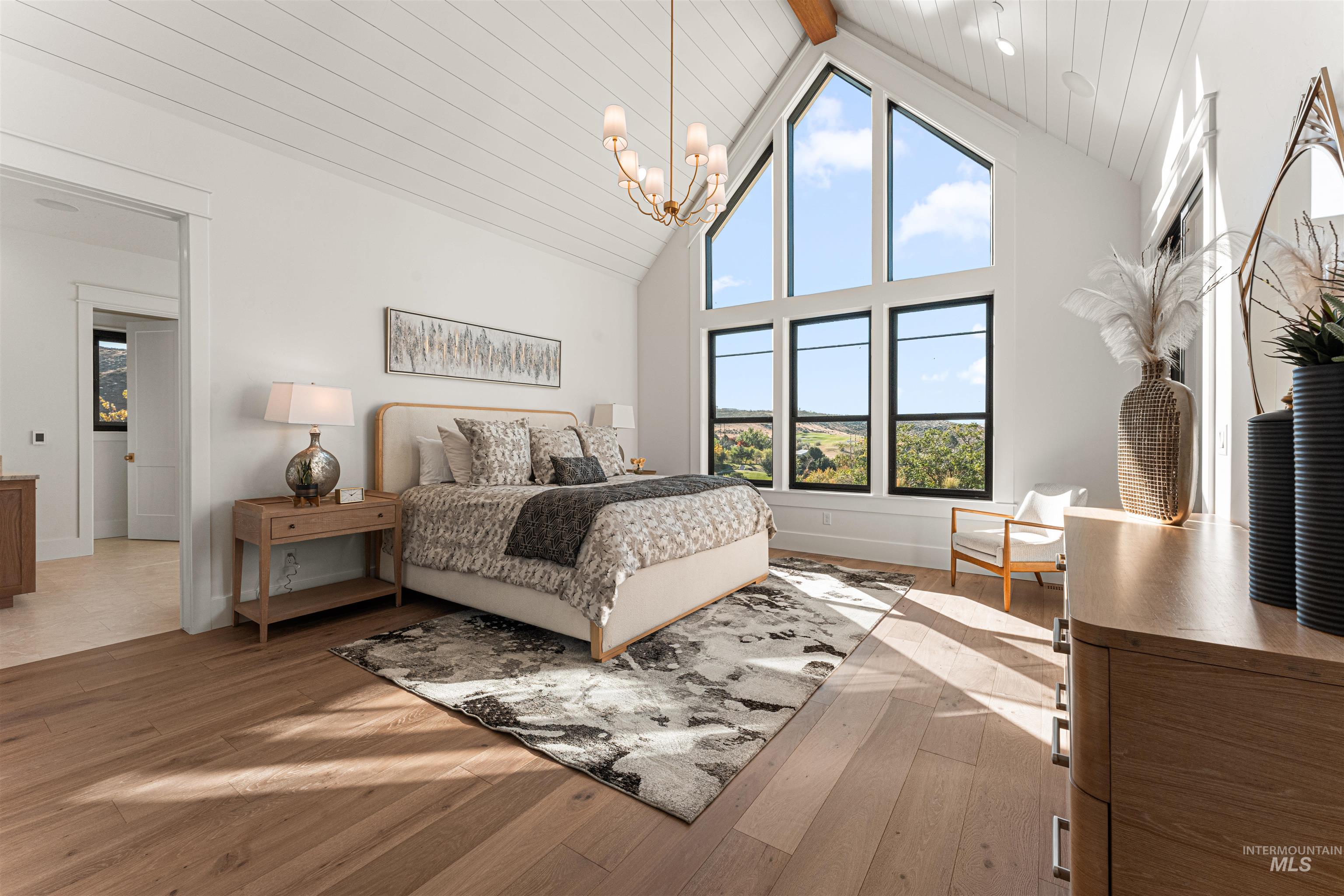 Bedroom featuring light wood finished floors, high vaulted ceiling, a chandelier, and a wooden ceiling with exposed beams