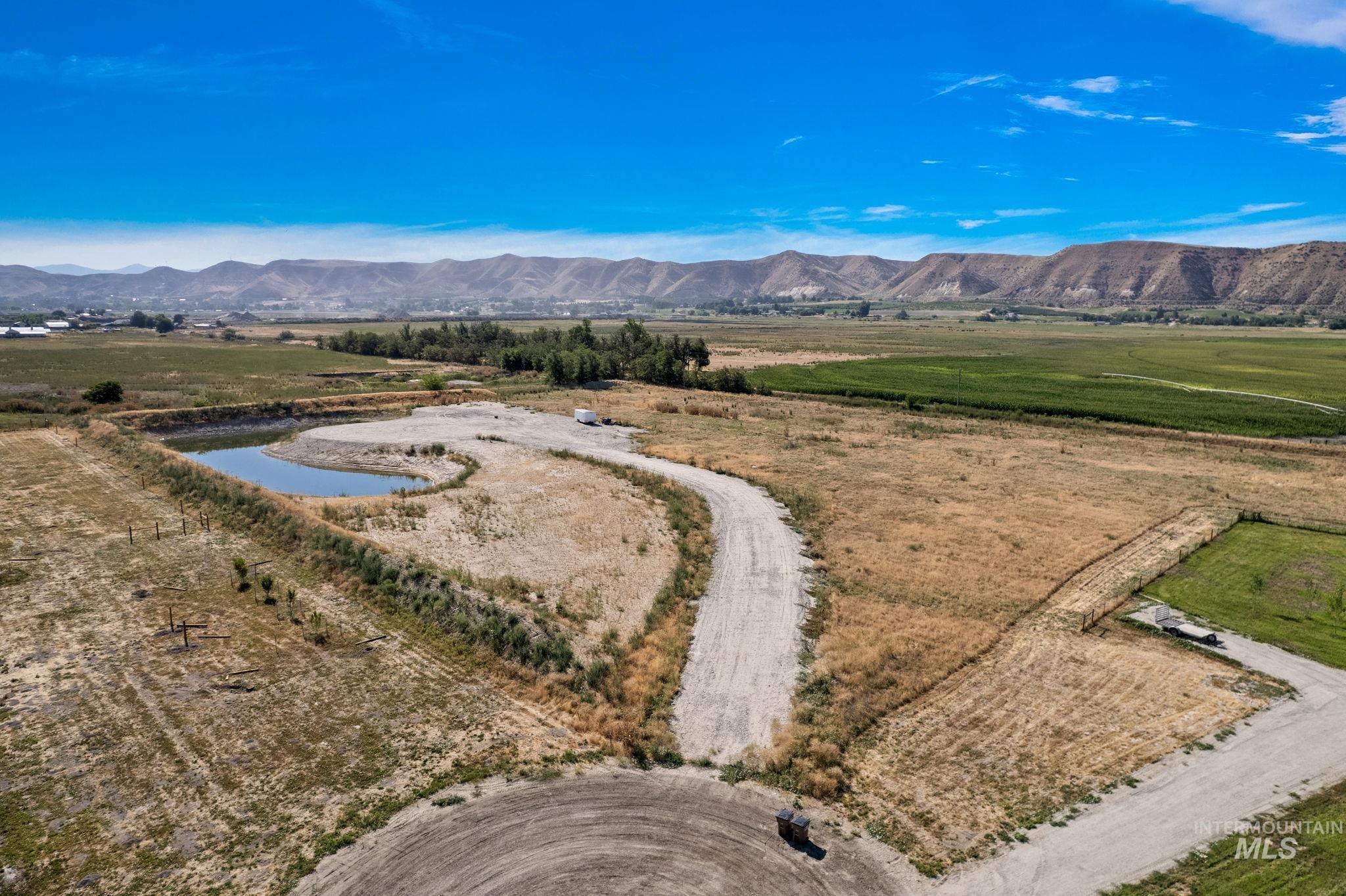 Overview of rural landscape featuring a pond and mountain view