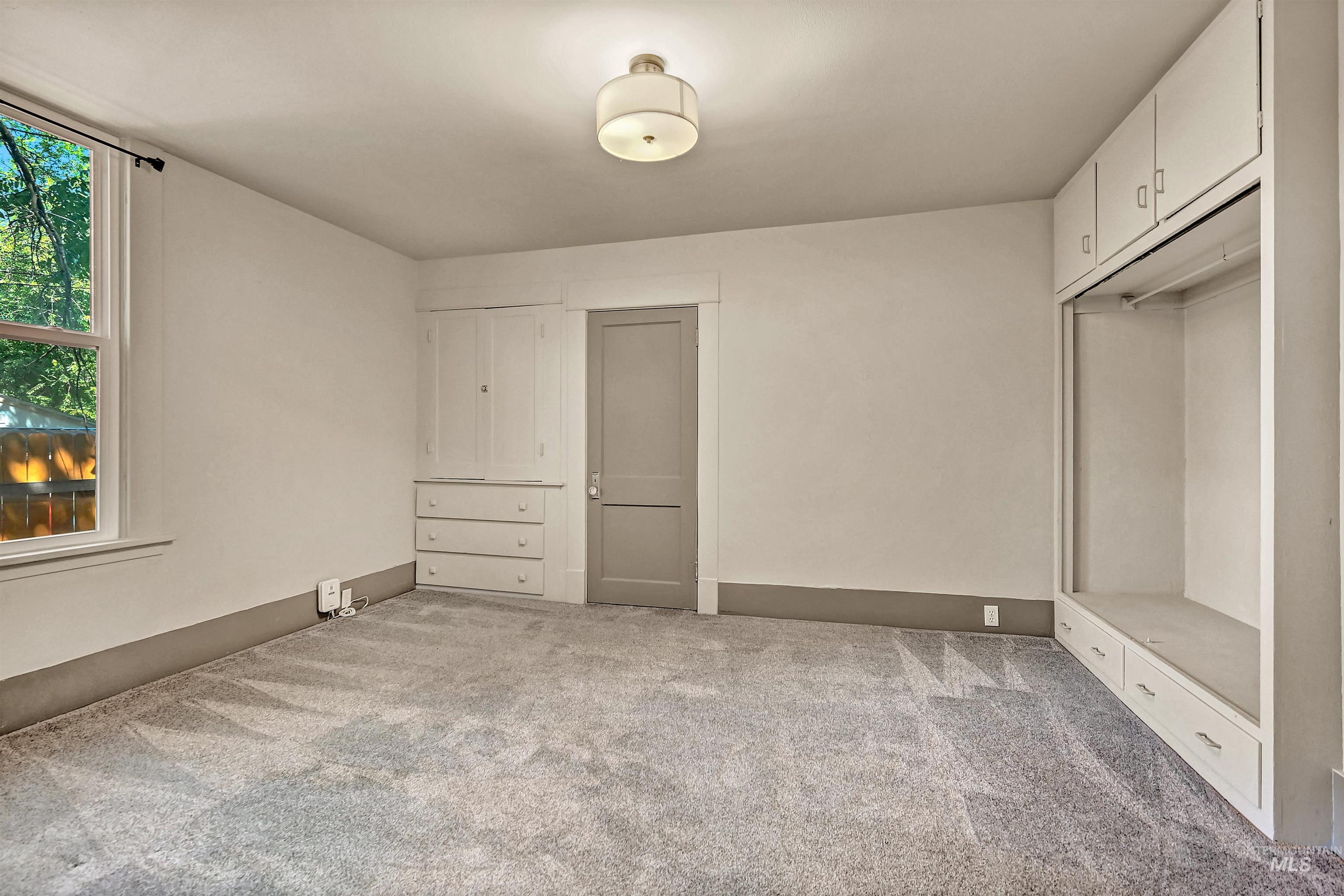 Unfurnished bedroom featuring light colored carpet and baseboards