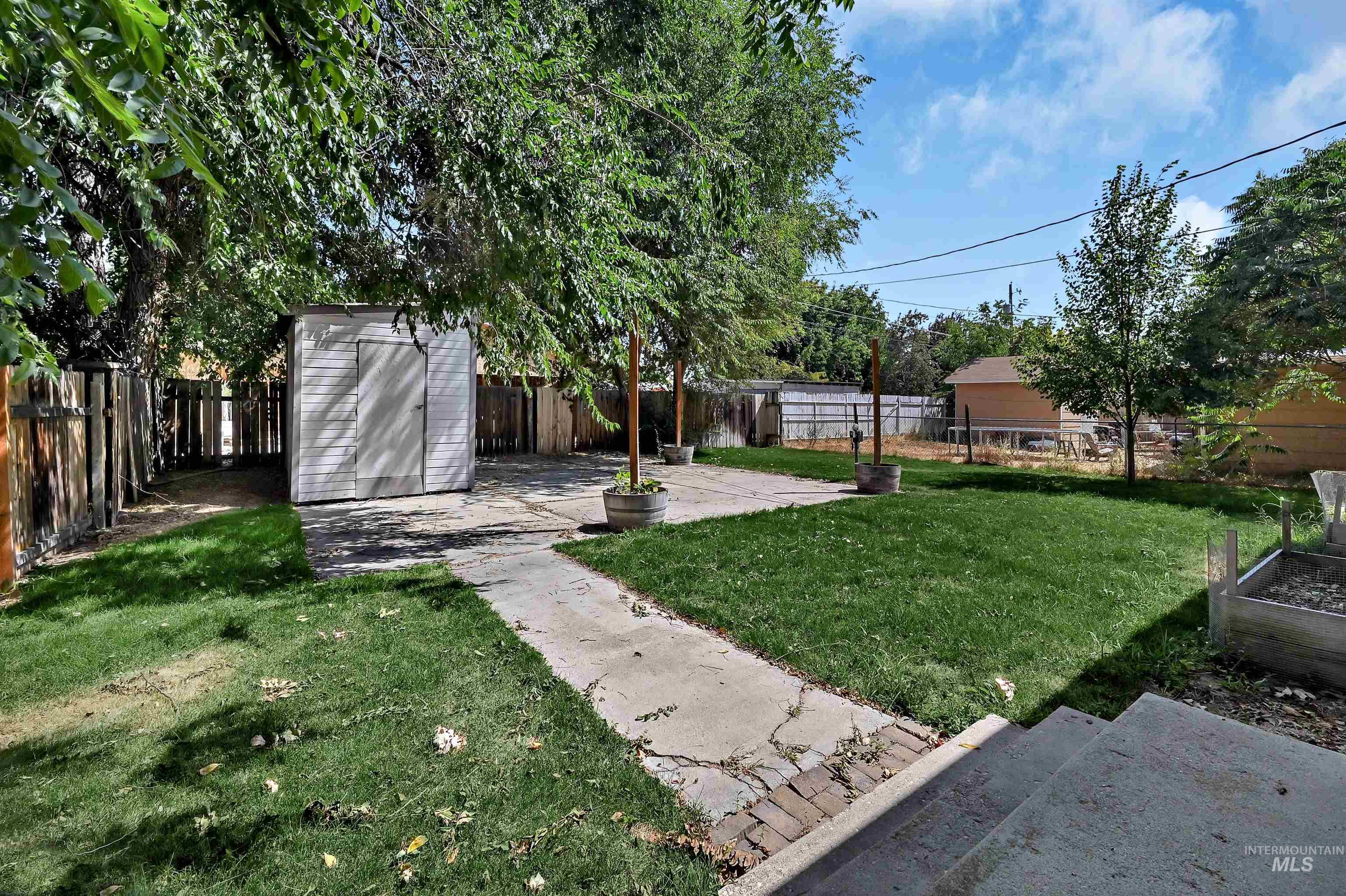 Fenced backyard with a patio and a storage shed