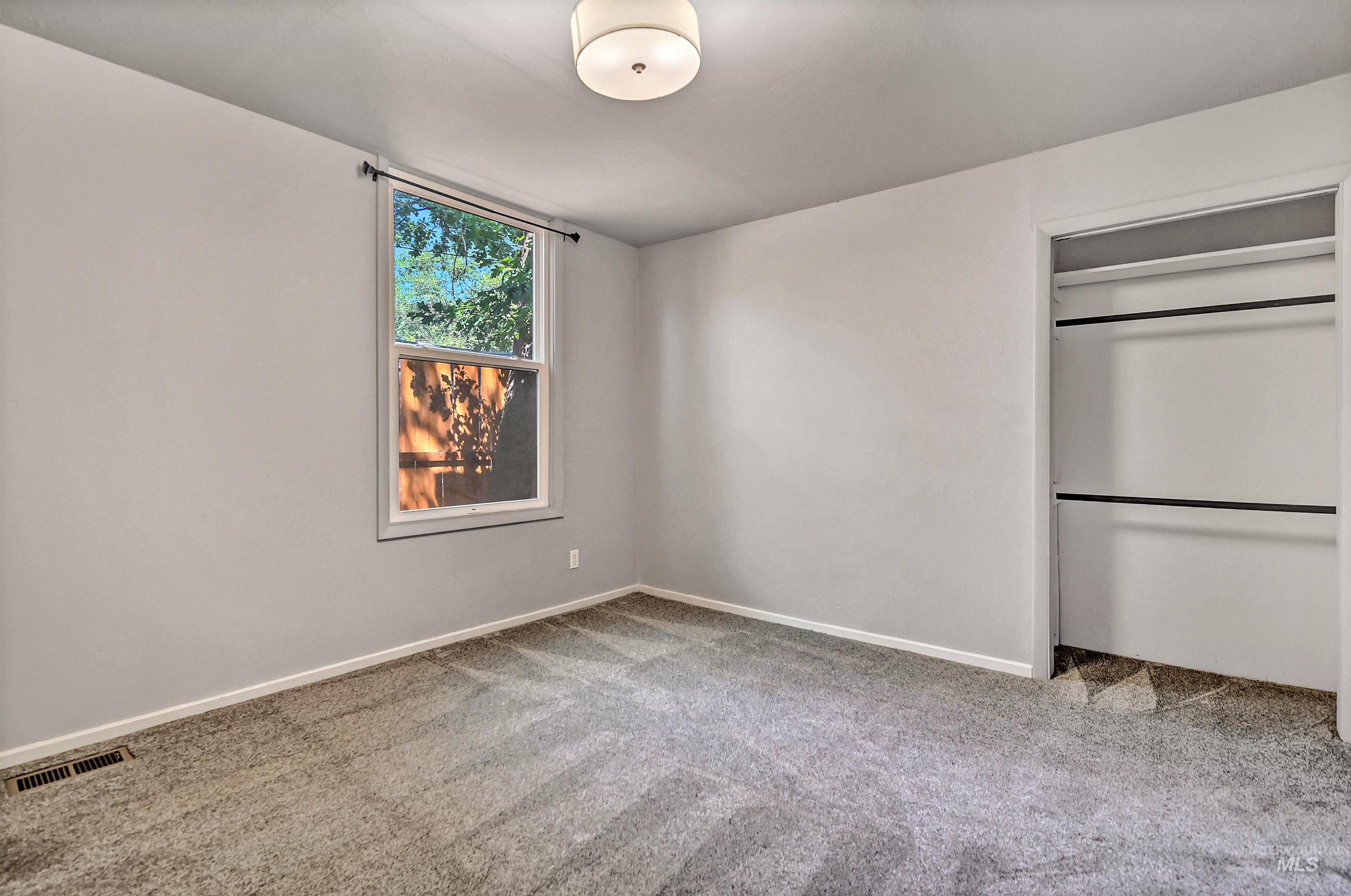 Unfurnished bedroom featuring light carpet and a closet
