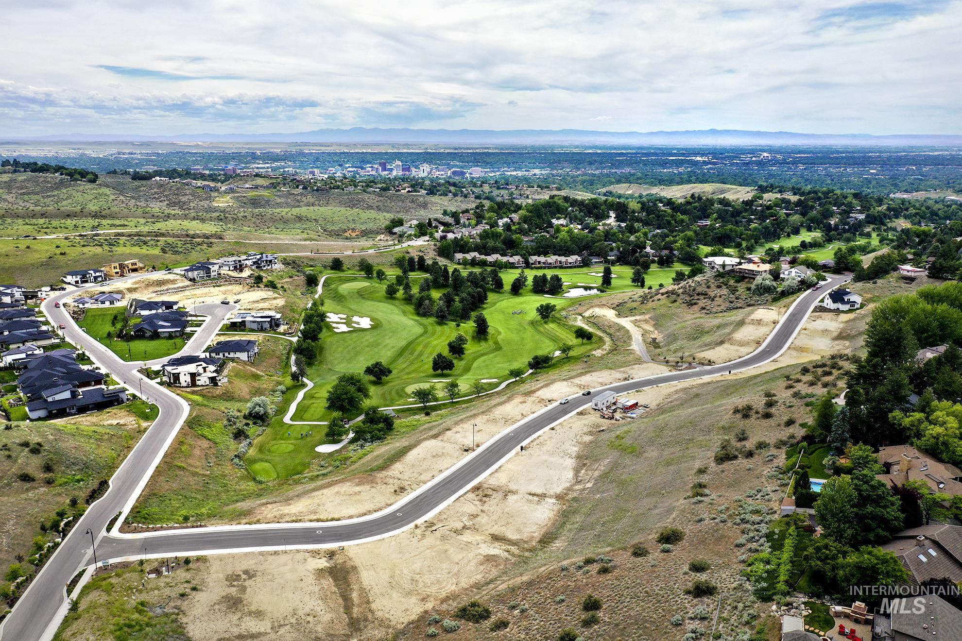 View of property location featuring nearby suburban area, a mountain backdrop, and a golf club