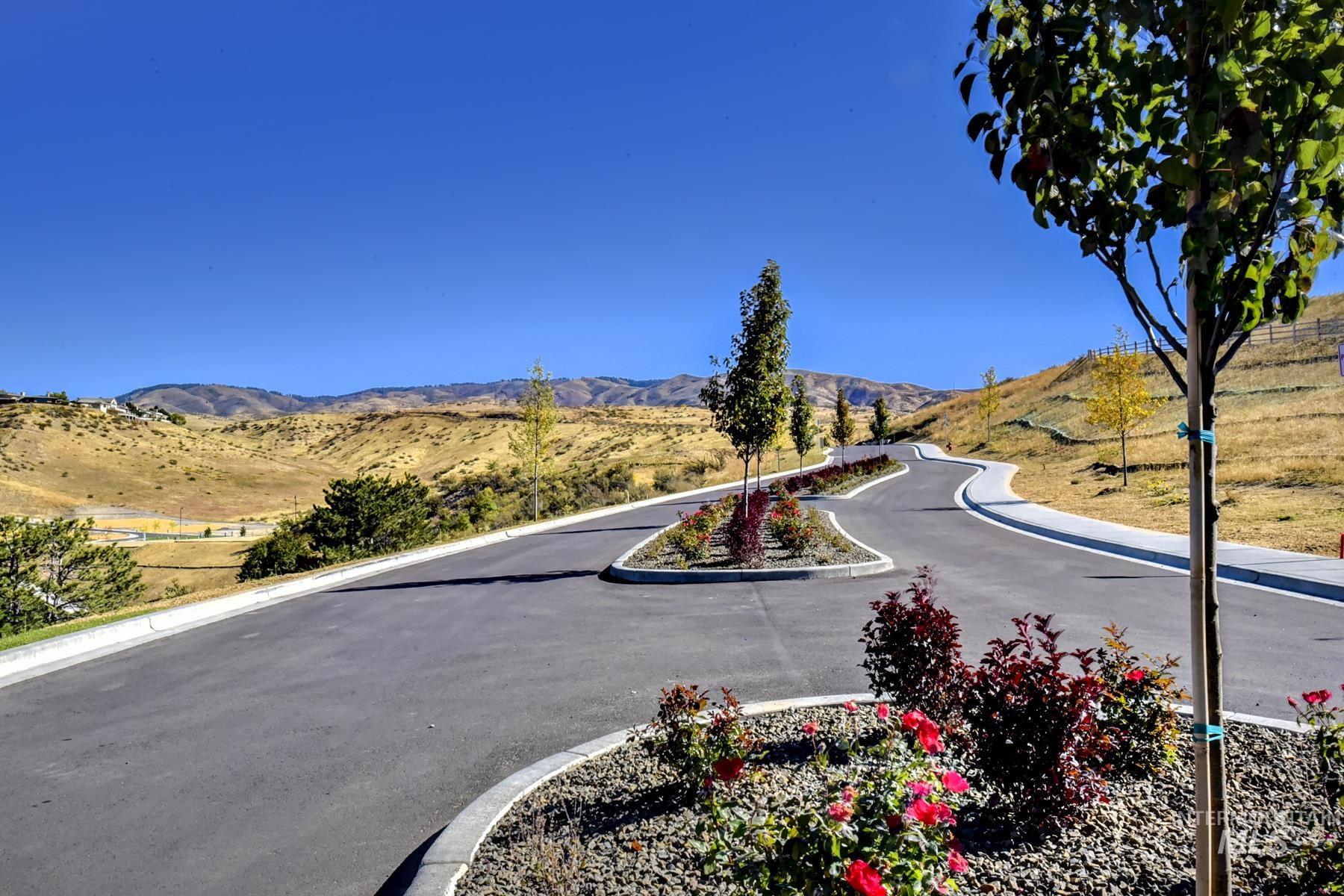 View of asphalt street featuring a mountain view and curbs