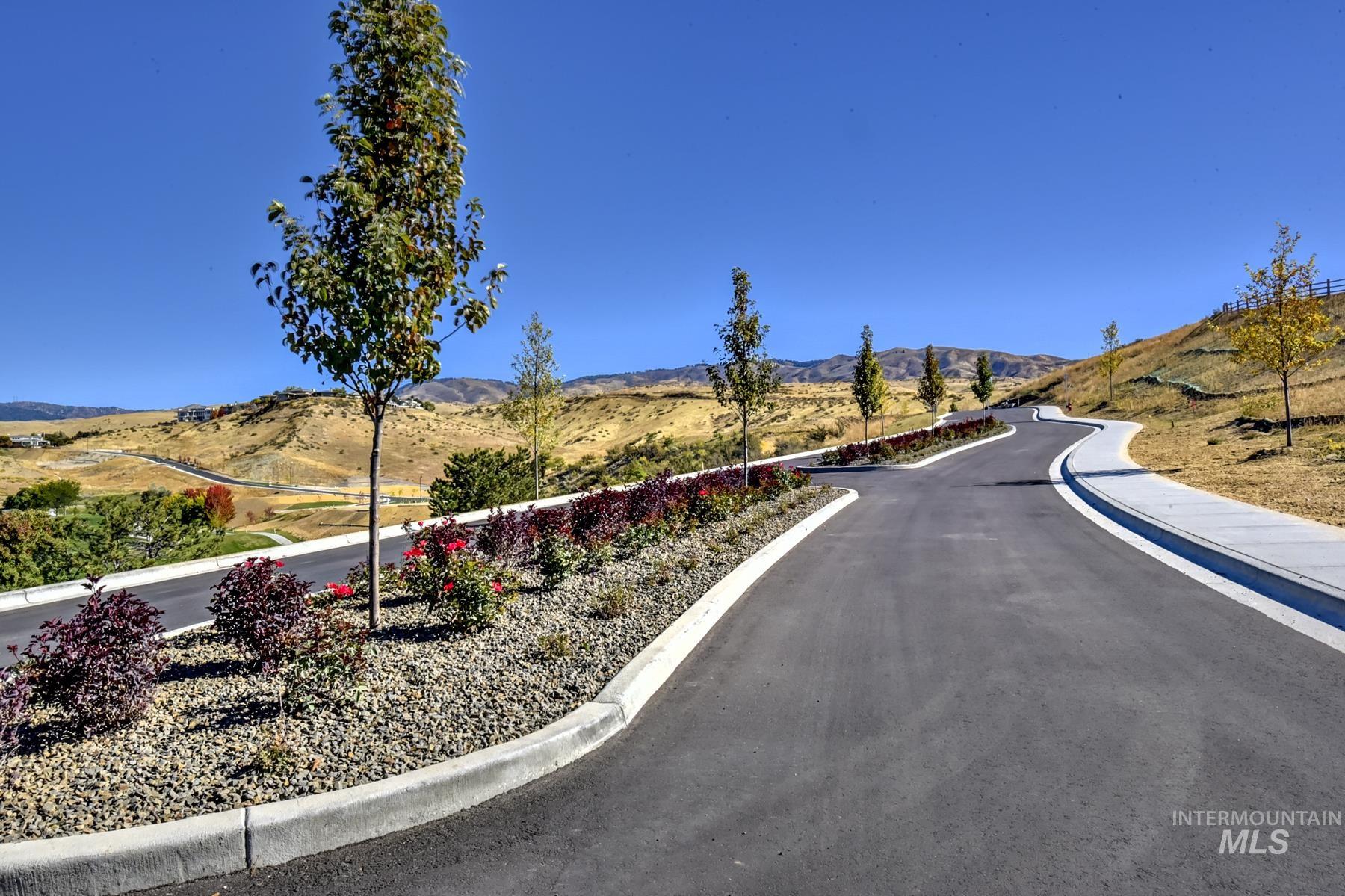 View of asphalt street with a mountain view and curbs