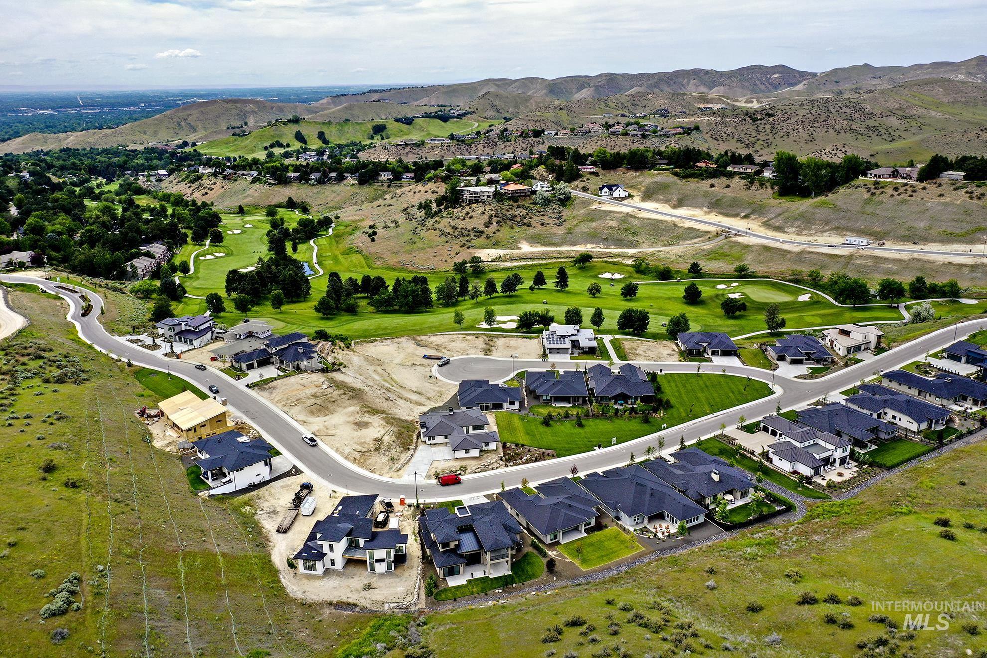 Aerial view of residential area featuring mountains and a local golf course
