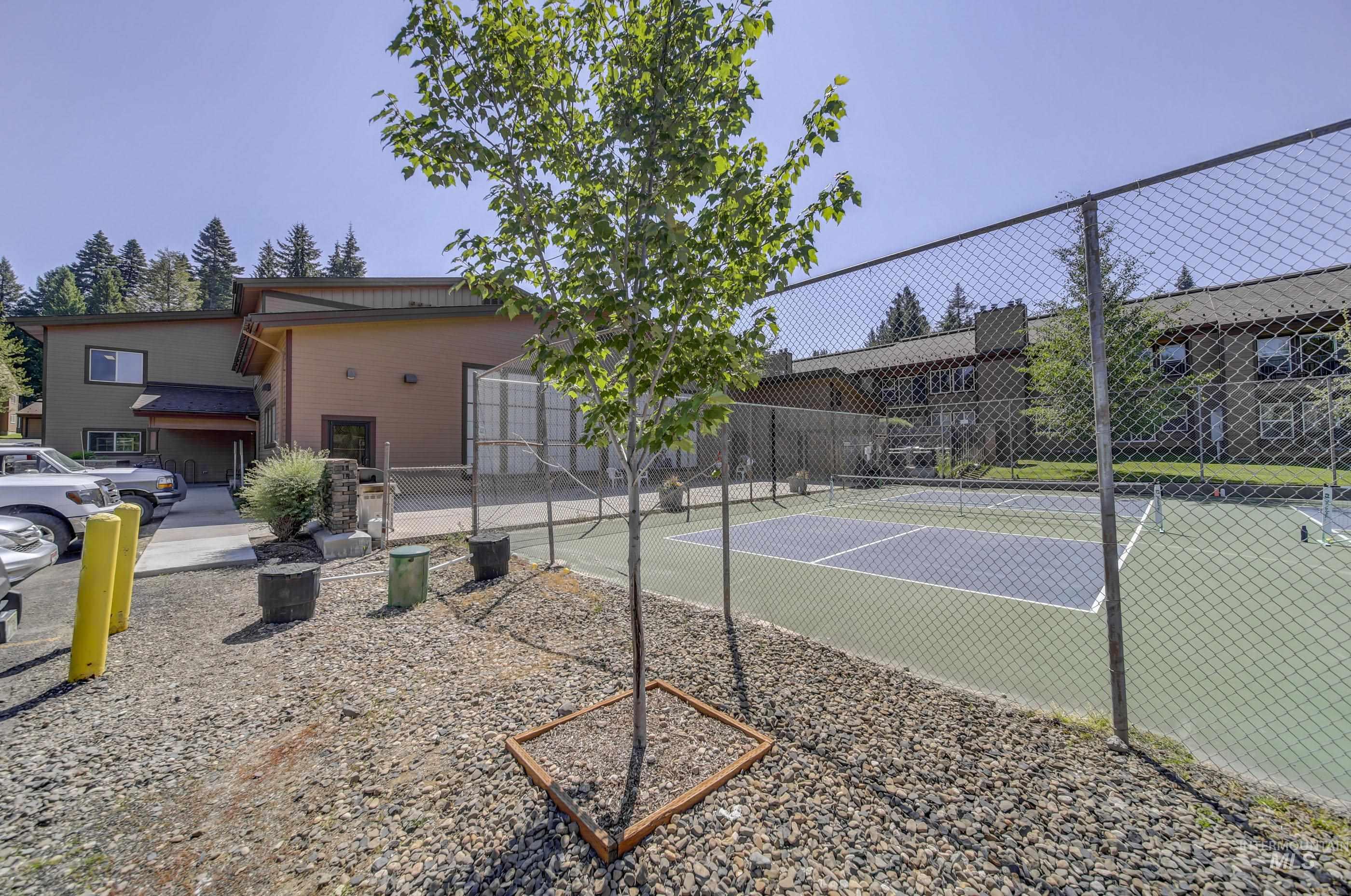 Fenced tennis court featuring a two-tone playing surface and chain-link enclosure