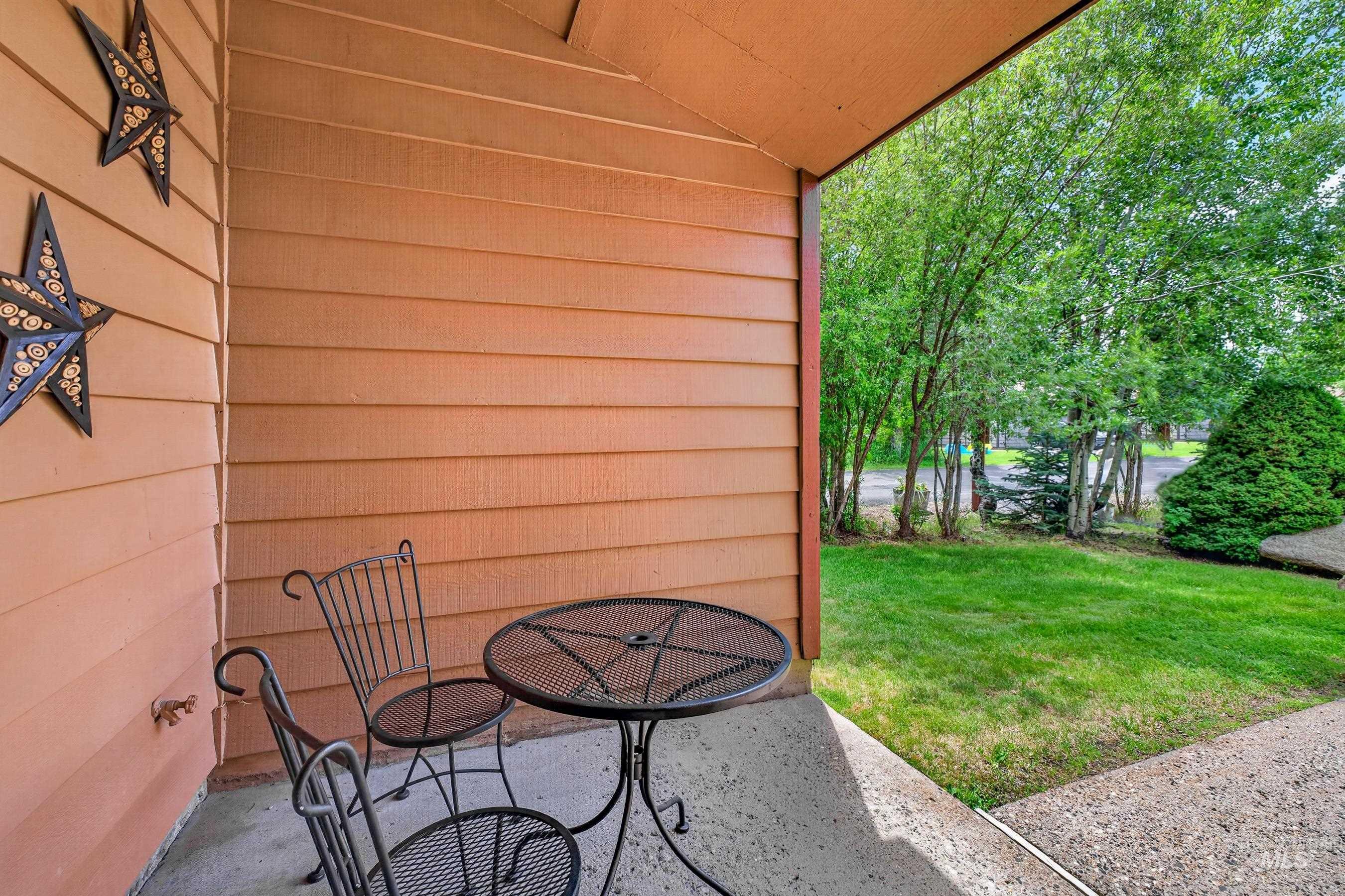 Covered patio with horizontal siding, concrete flooring, and a landscaped yard