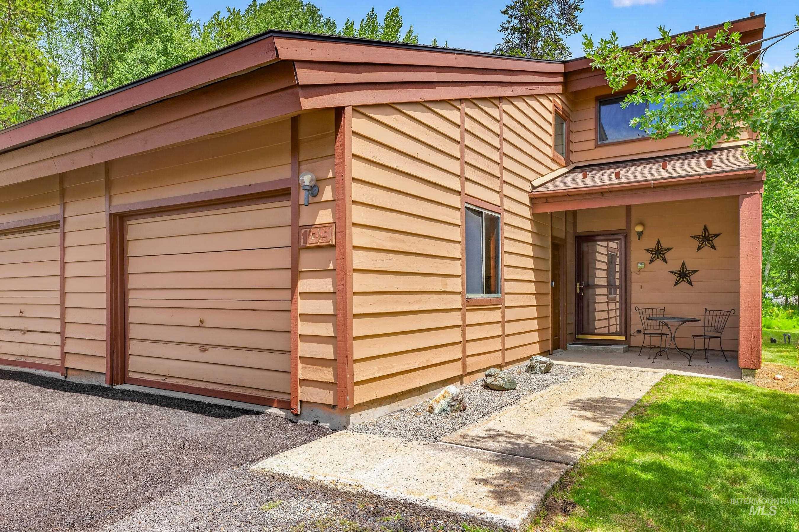 Multi-level exterior featuring horizontal wood siding and an asphalt driveway