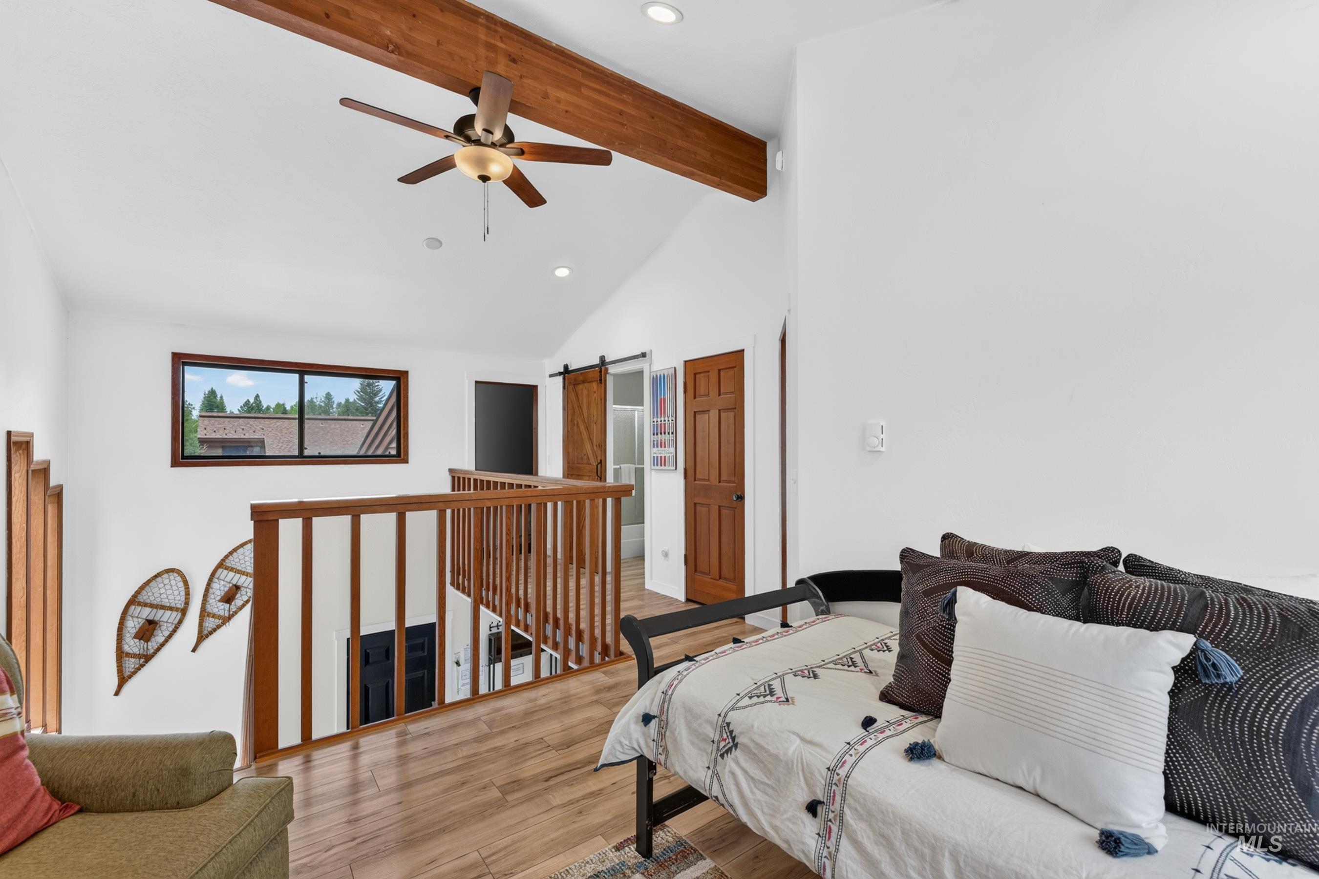 Vaulted ceiling with exposed wood beam and ceiling fan