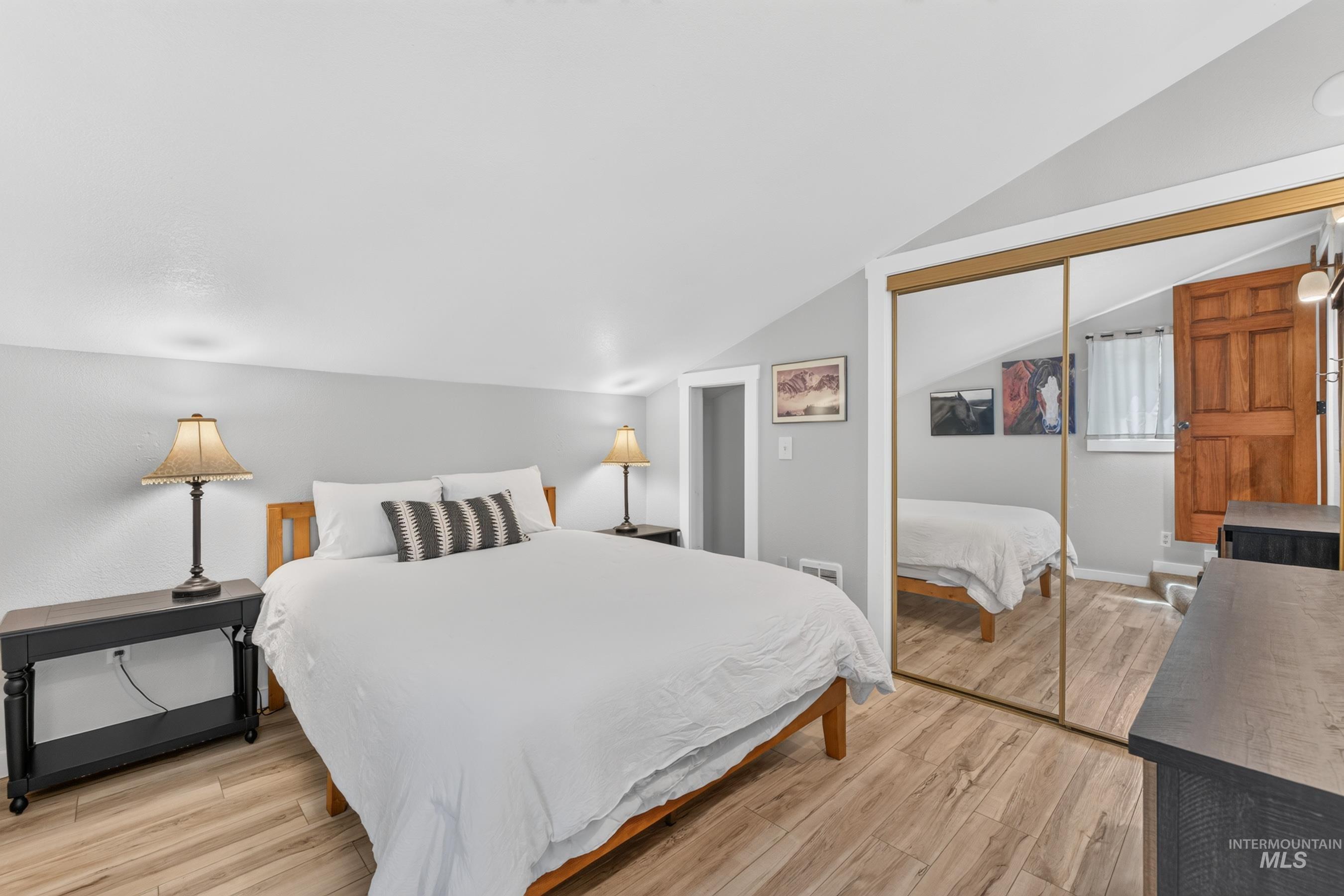 Sloped ceilings and light wood-finish flooring define this room