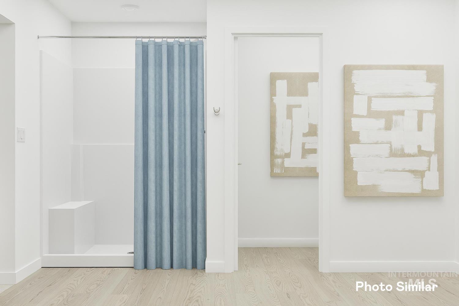 Full bath featuring wood finished floors and a shower with shower curtain