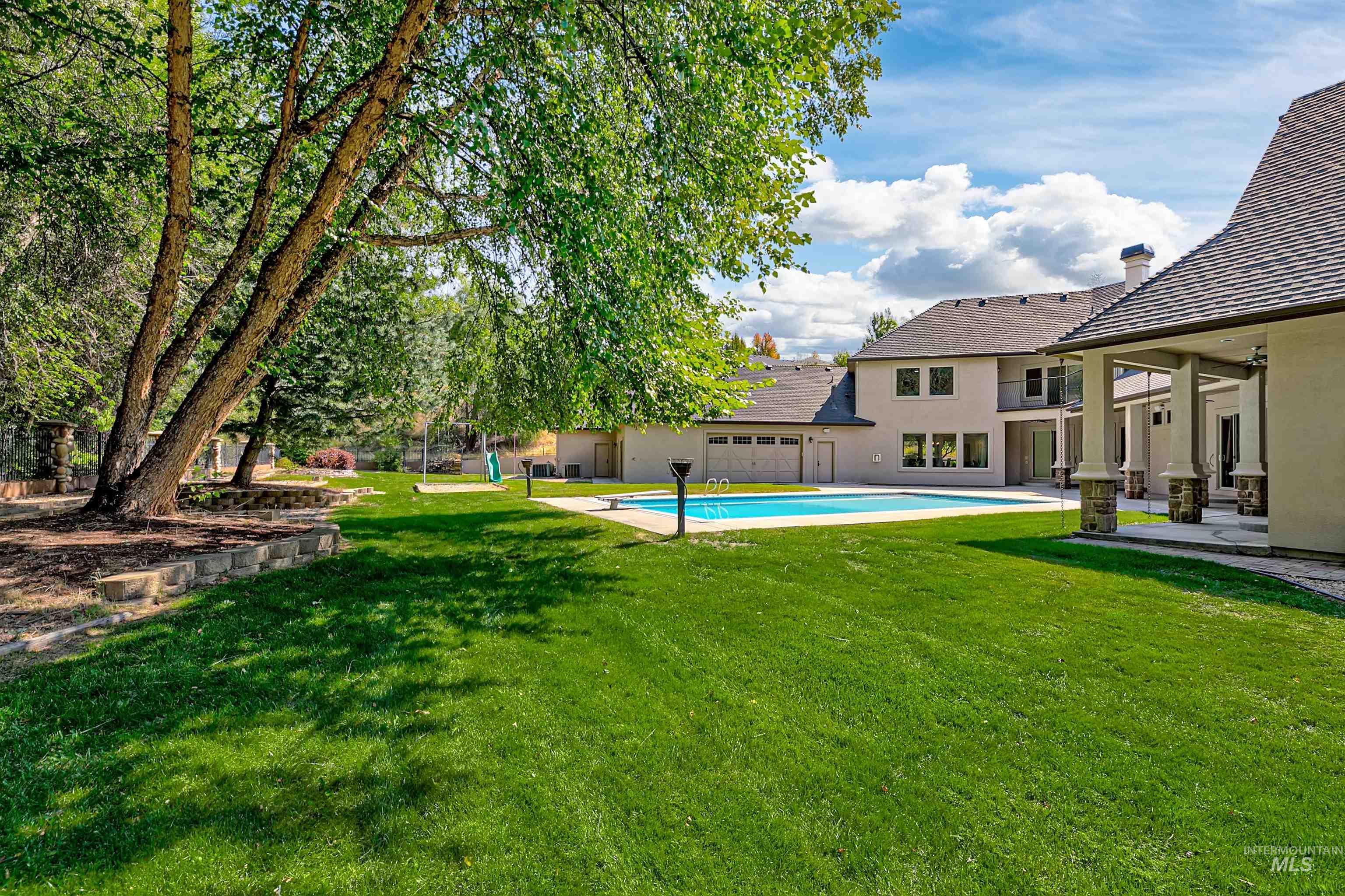 View of grassy yard featuring a patio and an outdoor pool