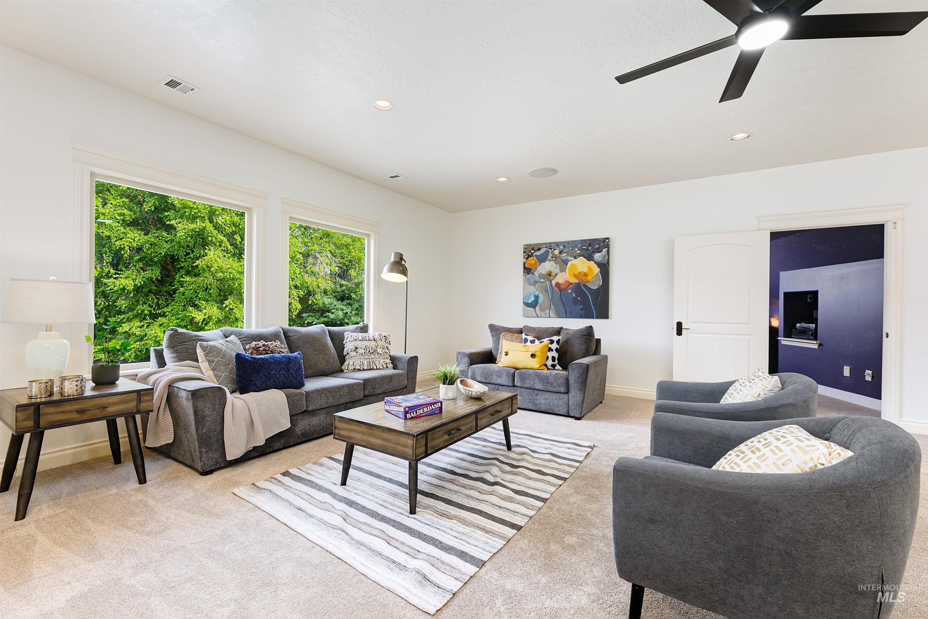 Living room with light colored carpet, recessed lighting, and ceiling fan
