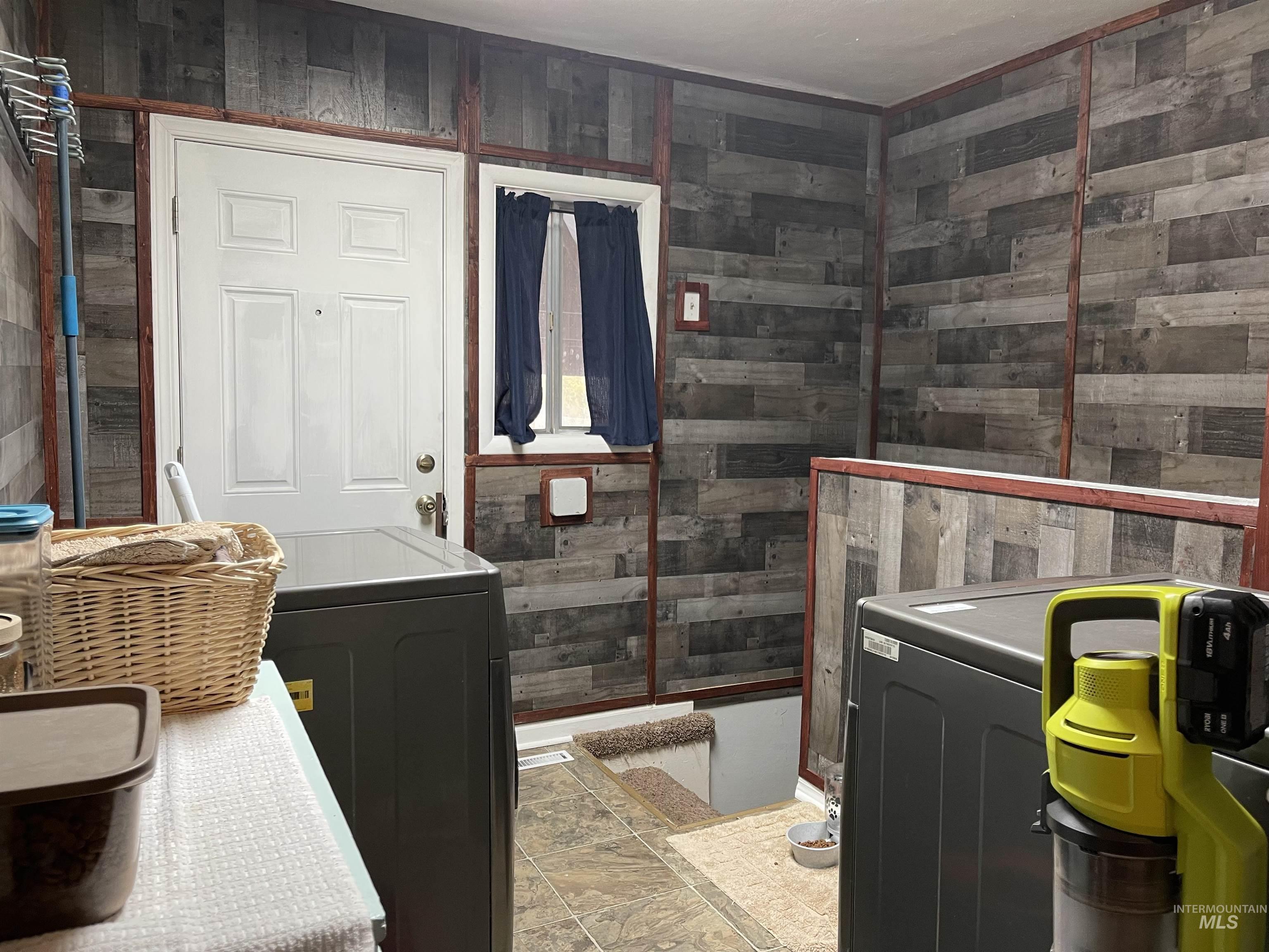 Laundry featuring wood walls