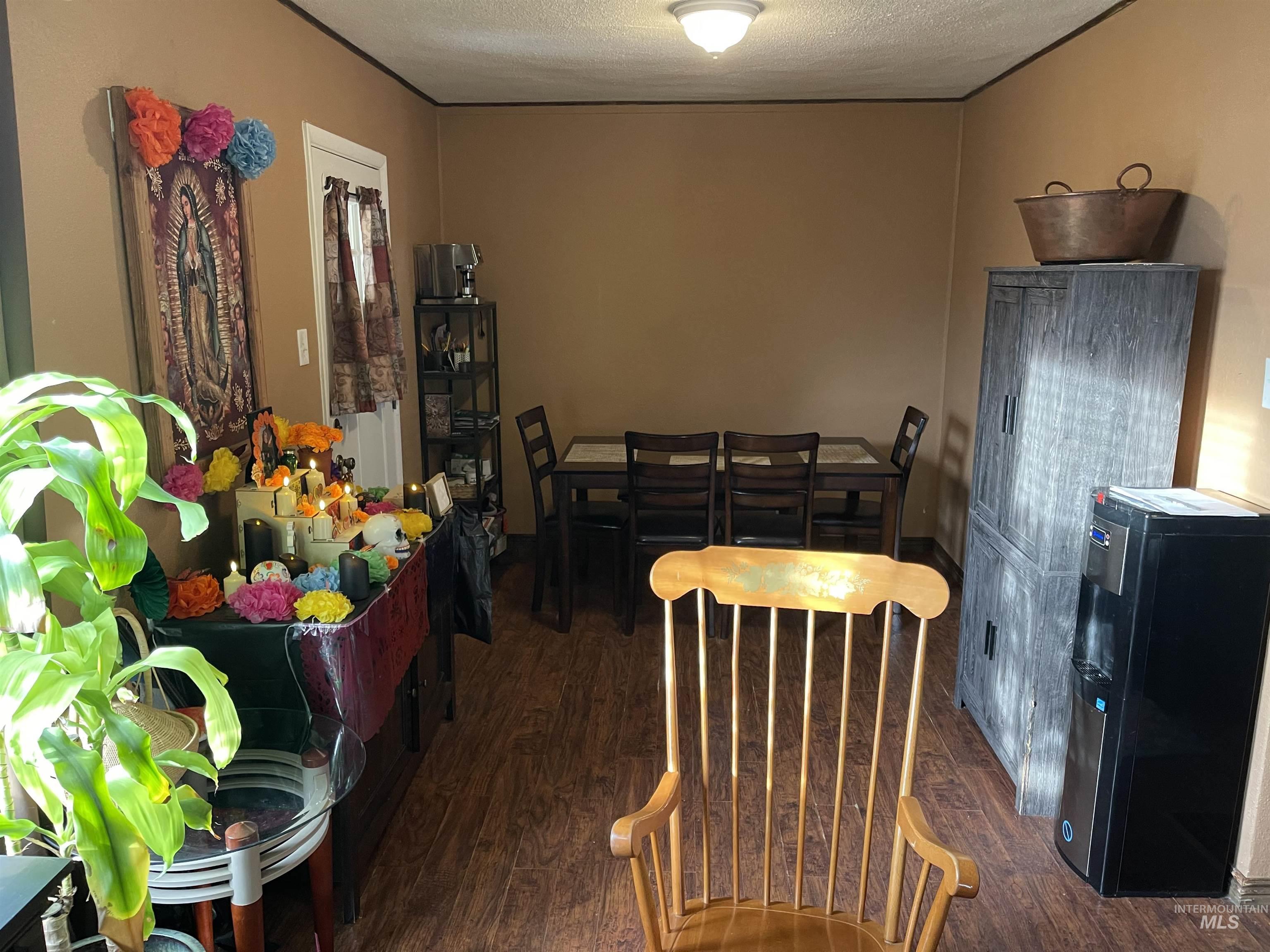 Dining space featuring dark wood-type flooring and a textured ceiling