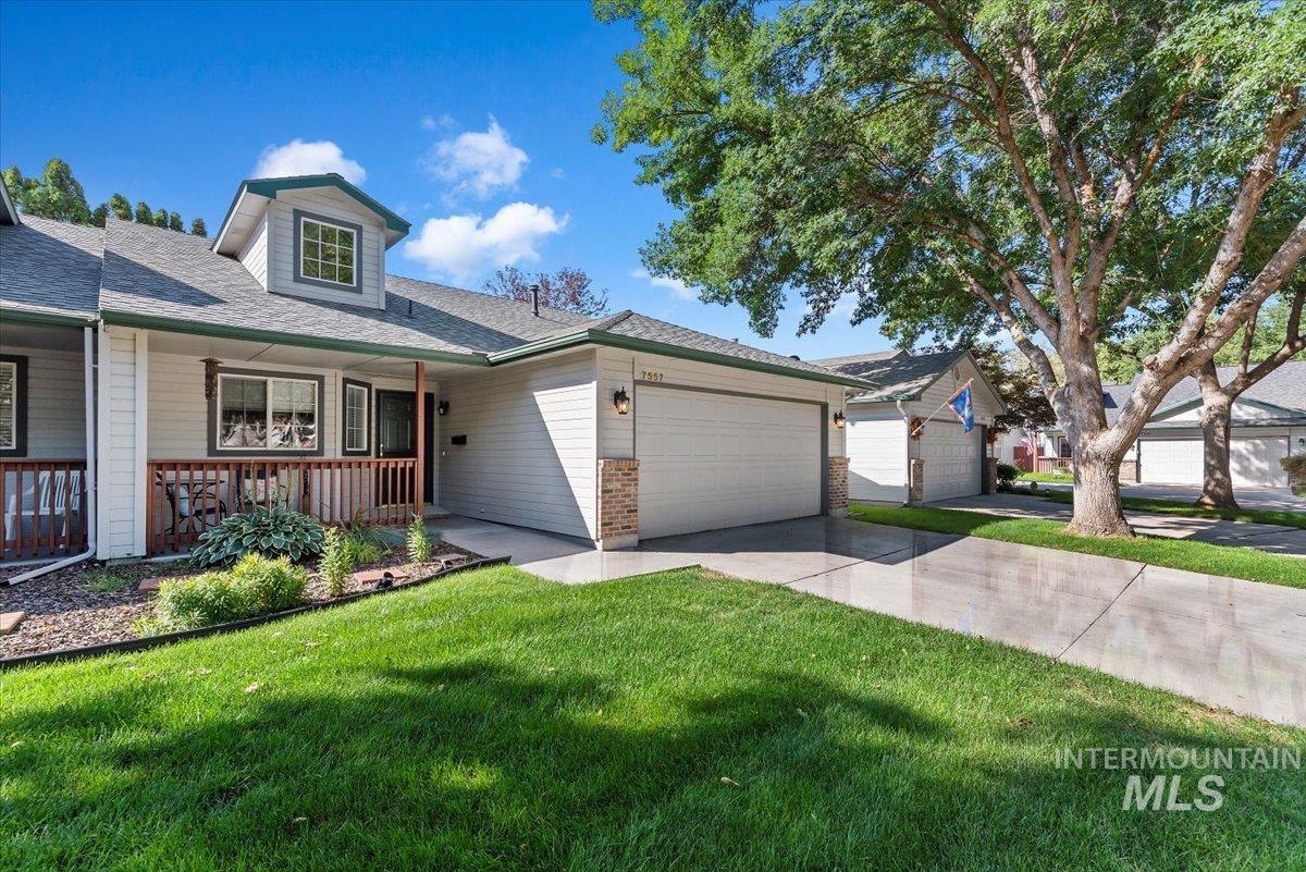 View of front facade featuring roof with shingles, a front lawn, concrete driveway, covered porch, and a garage