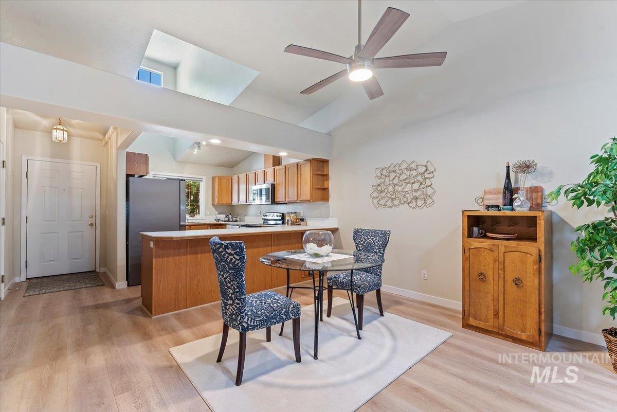 Dining area with lofted ceiling, light wood-style flooring, and ceiling fan