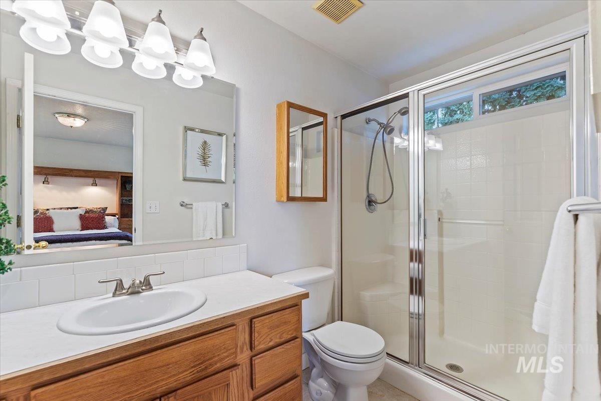 Bathroom with ensuite bath, a shower stall, and vanity