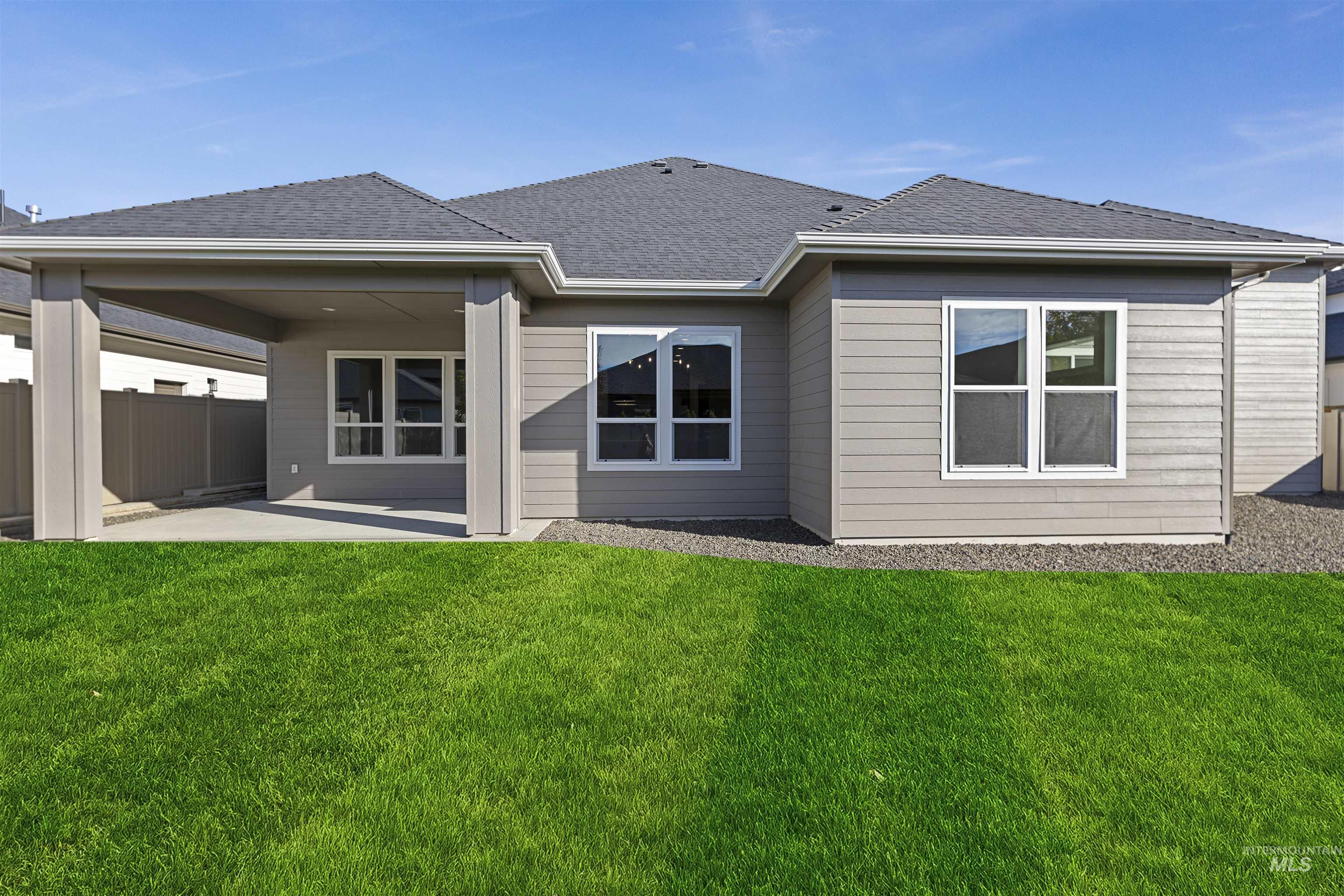 Back of house featuring a patio area and roof with shingles