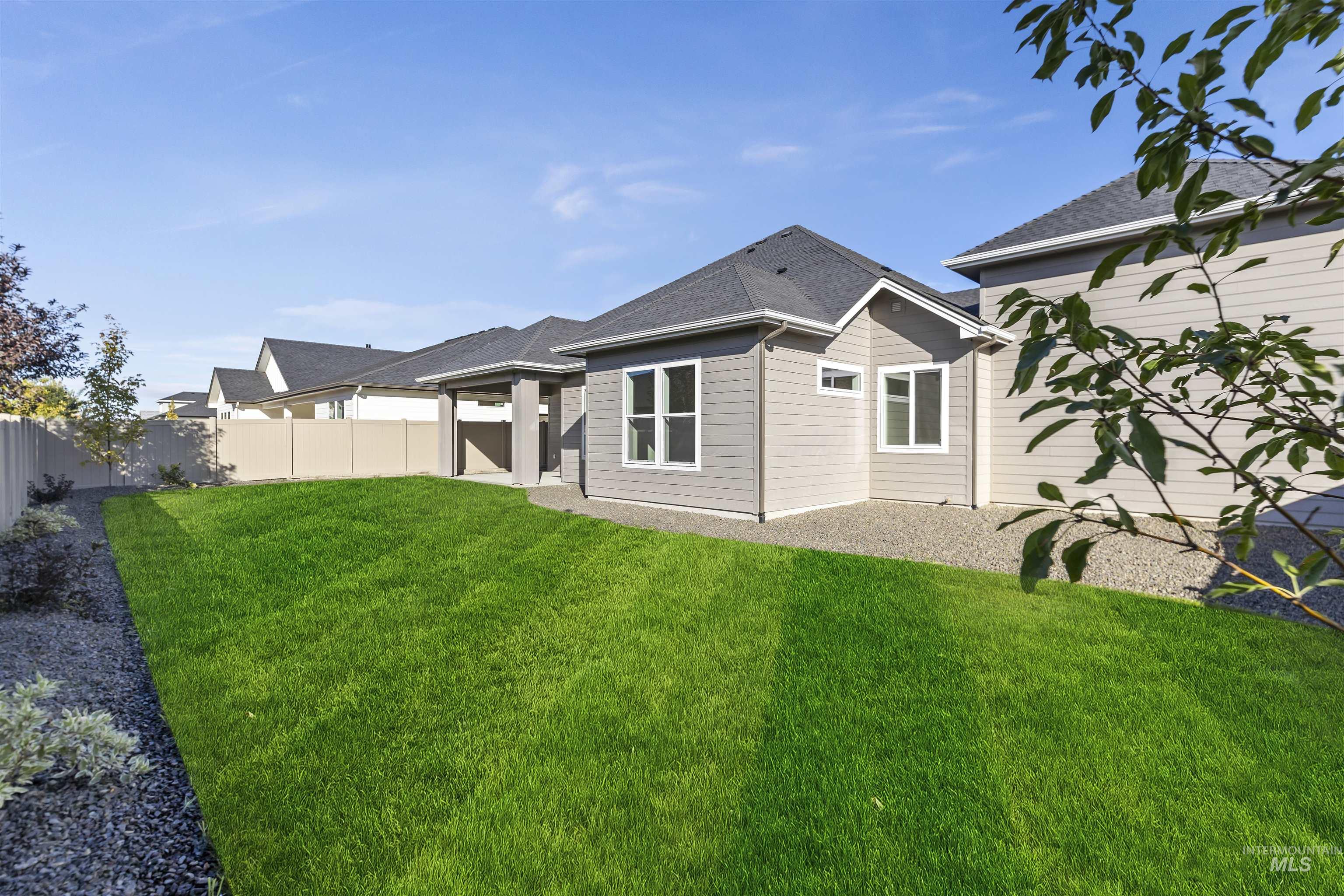 Rear view of house with a patio, a fenced backyard, and roof with shingles