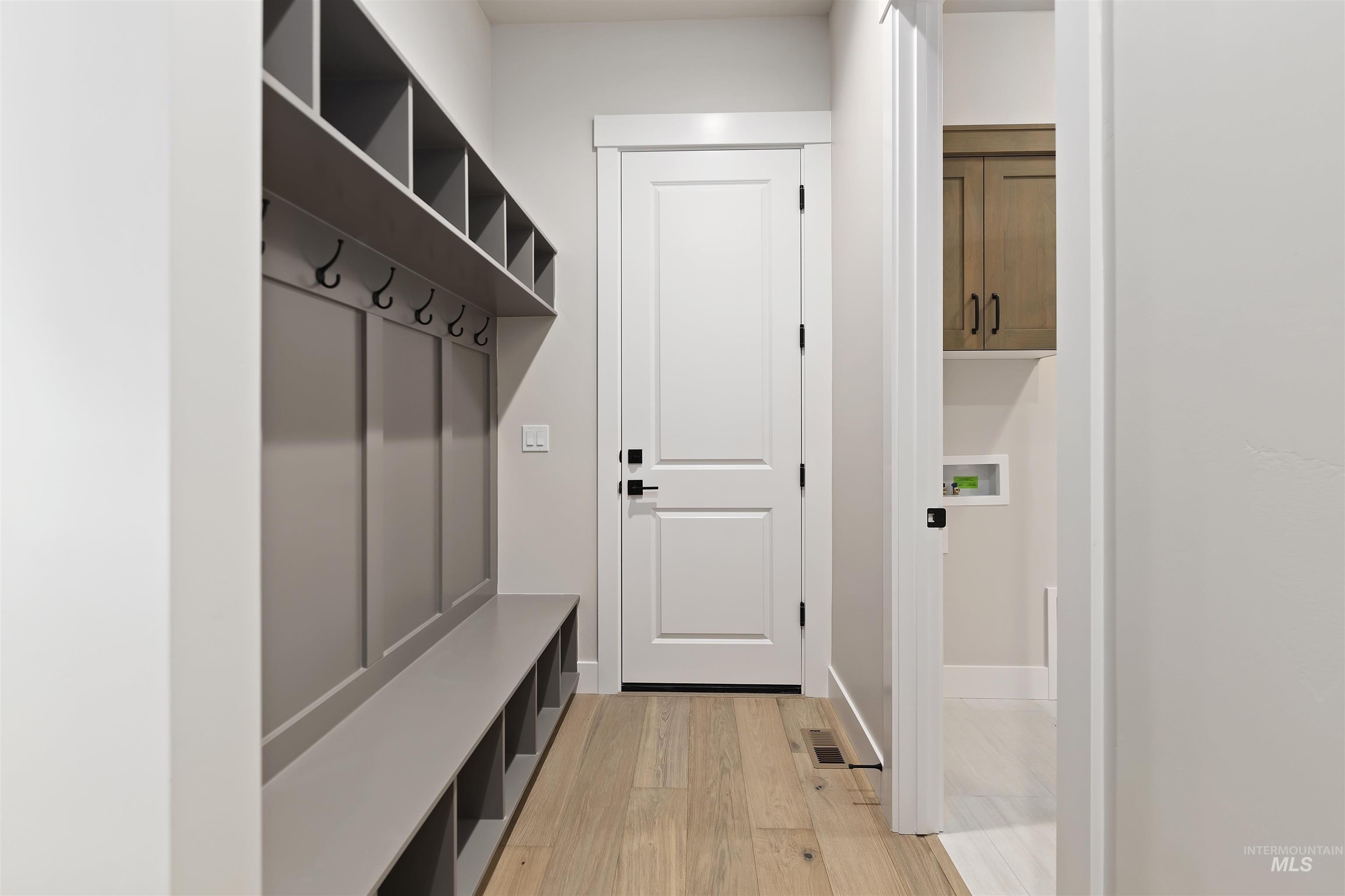 Mudroom with light wood-type flooring and baseboards