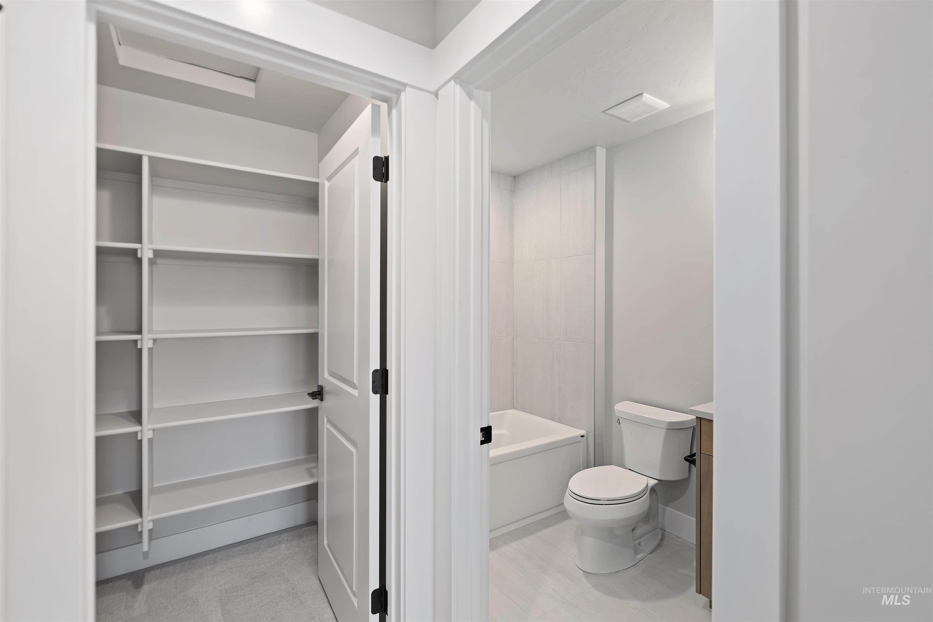 Bathroom with toilet and a tub in Bonus Room