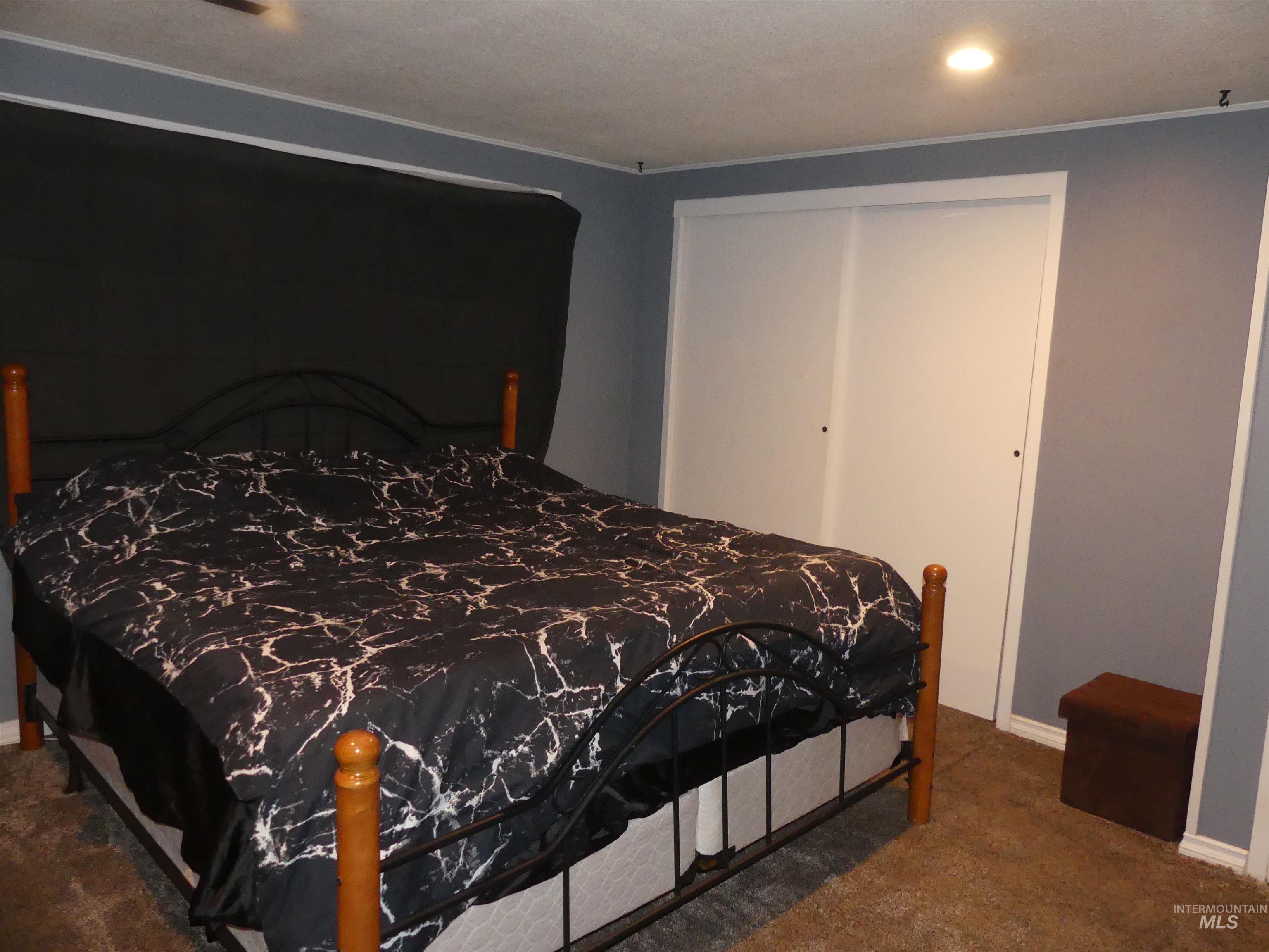 Bedroom with dark carpet, a closet, and recessed lighting