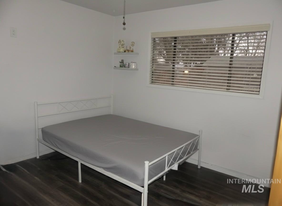 Bedroom with dark wood-style flooring