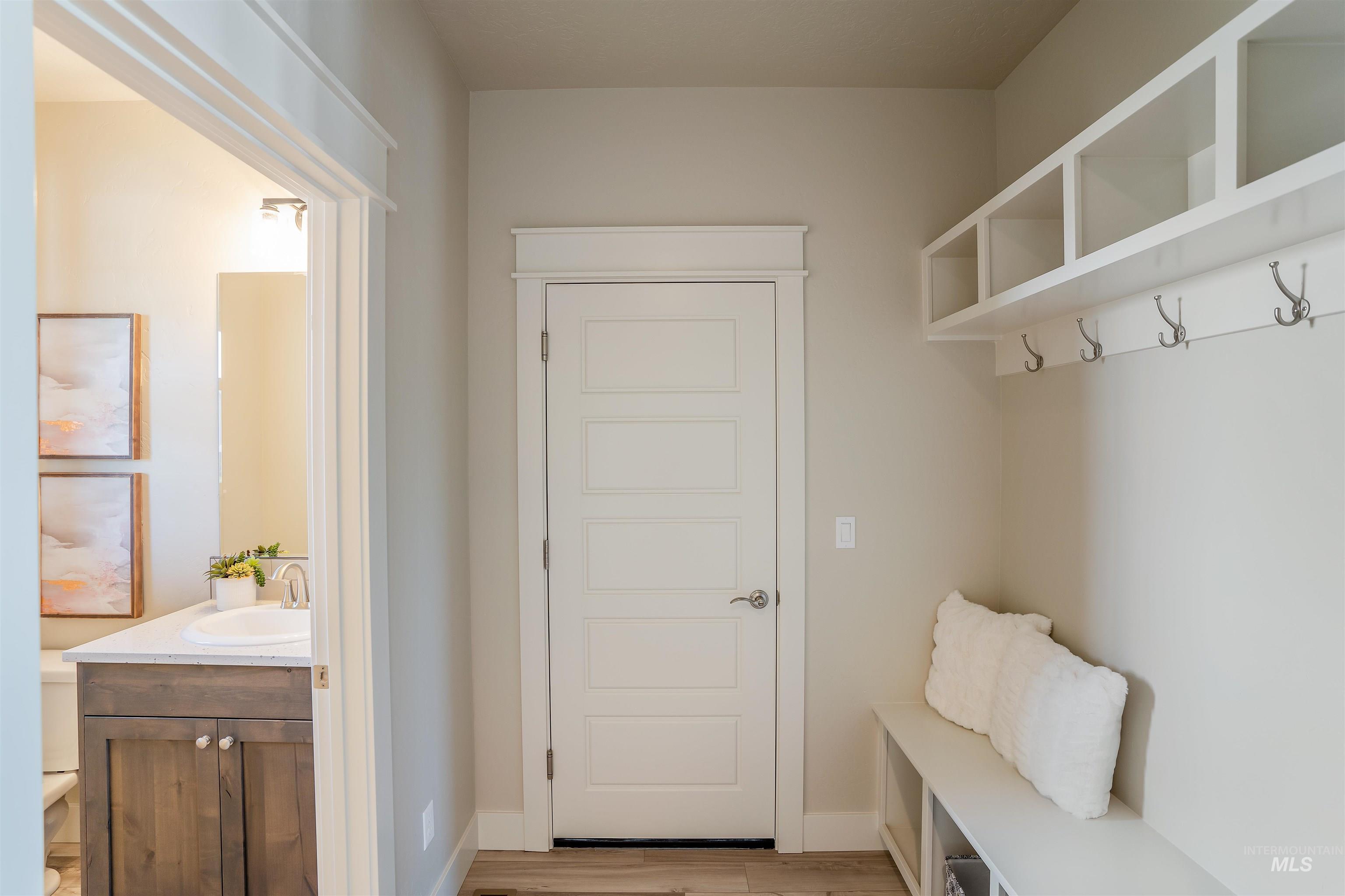 Mudroom with light wood-style floors and baseboards
