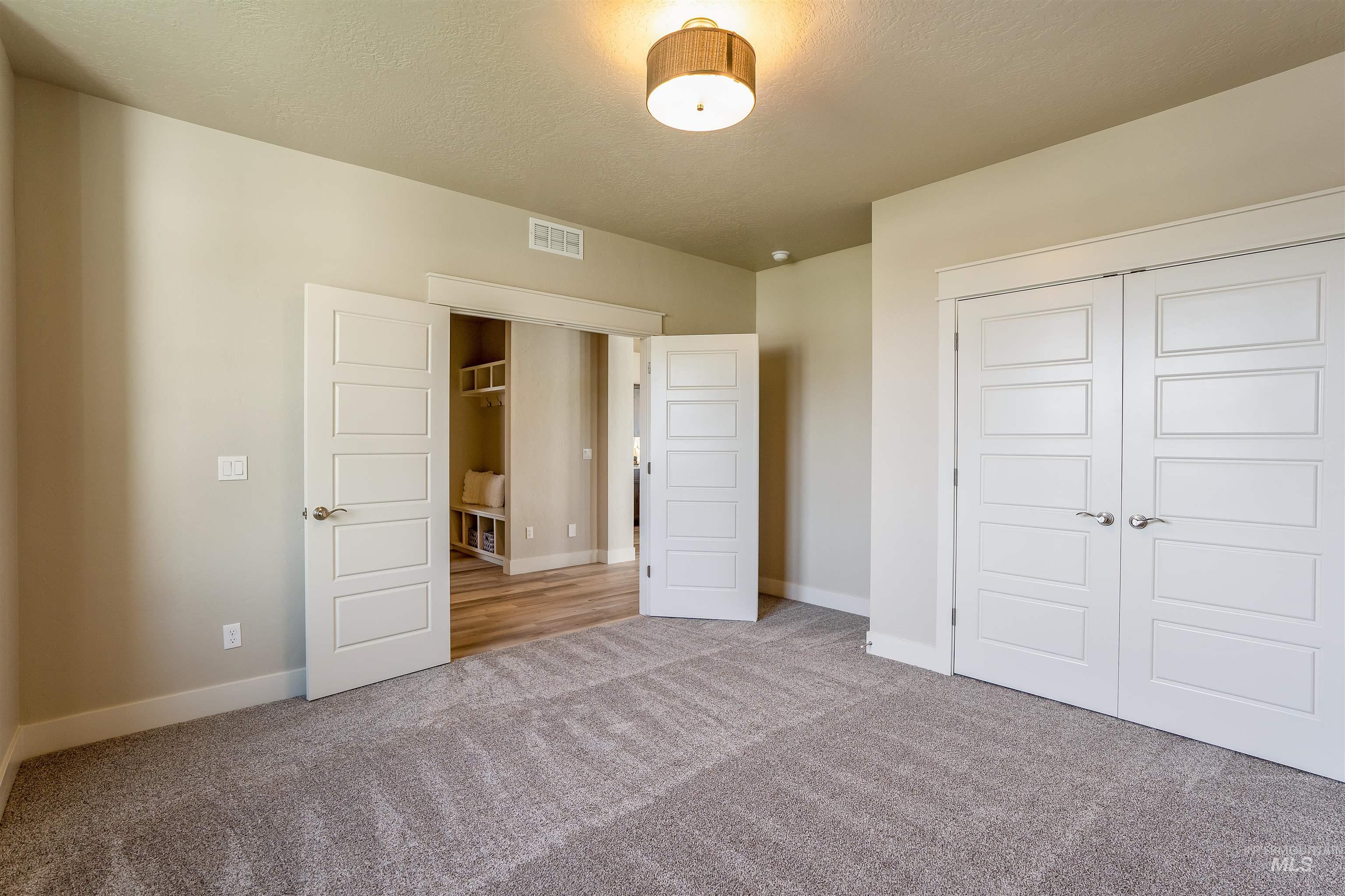 Unfurnished bedroom featuring carpet flooring, a closet, and a textured ceiling