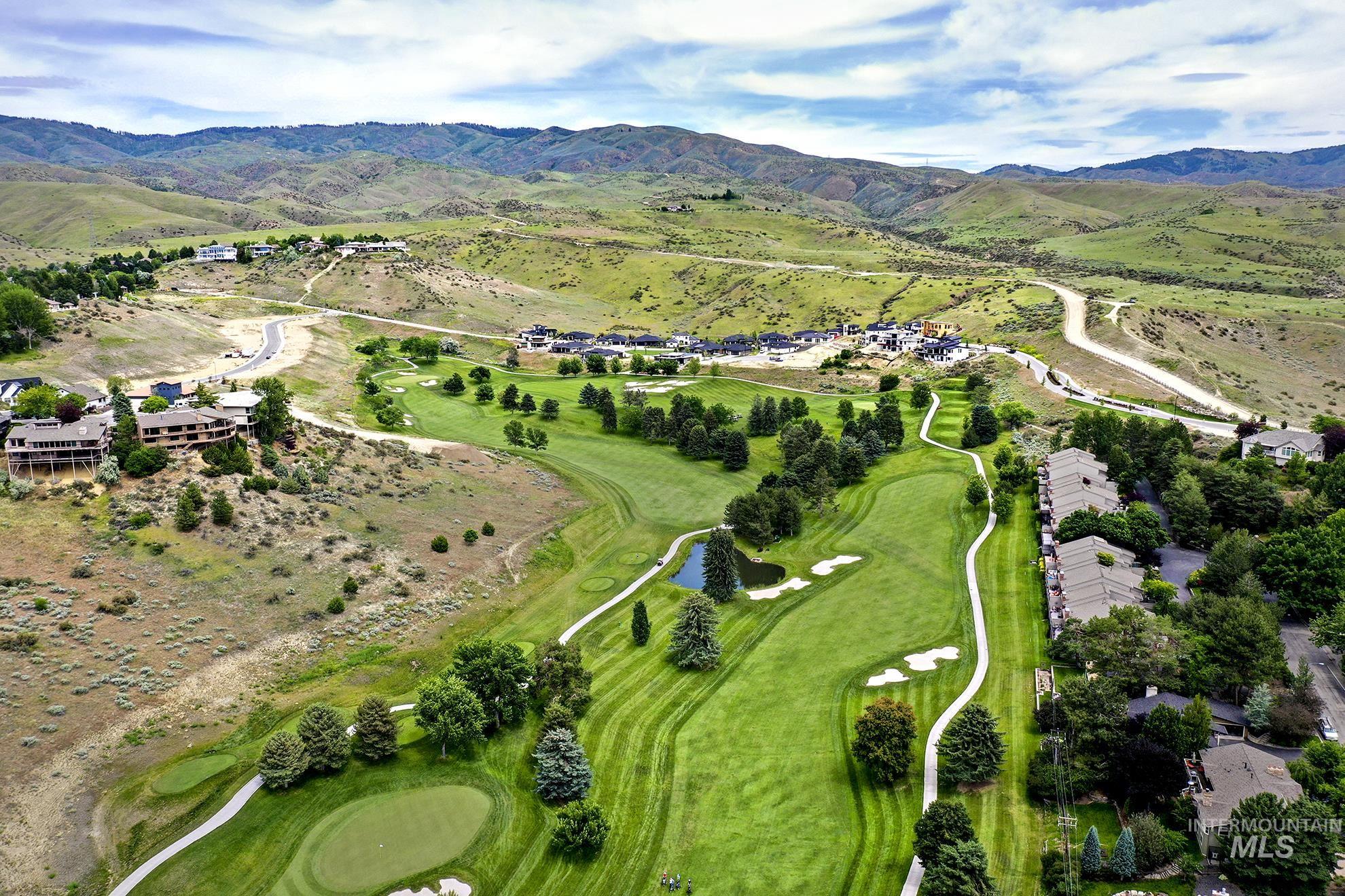 Aerial overview of property's location featuring a water and mountain view and a golf course