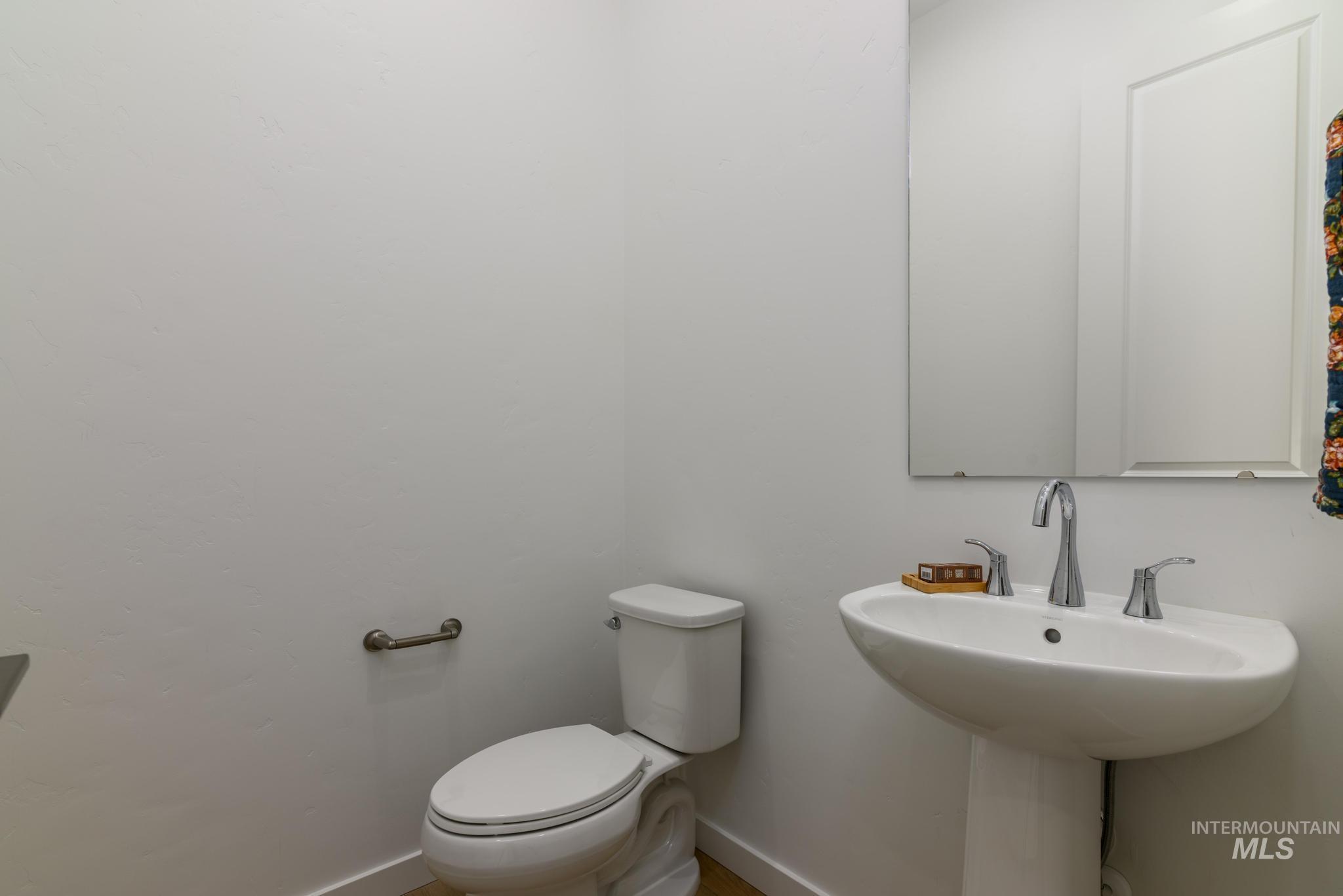 Half bathroom featuring toilet and baseboards