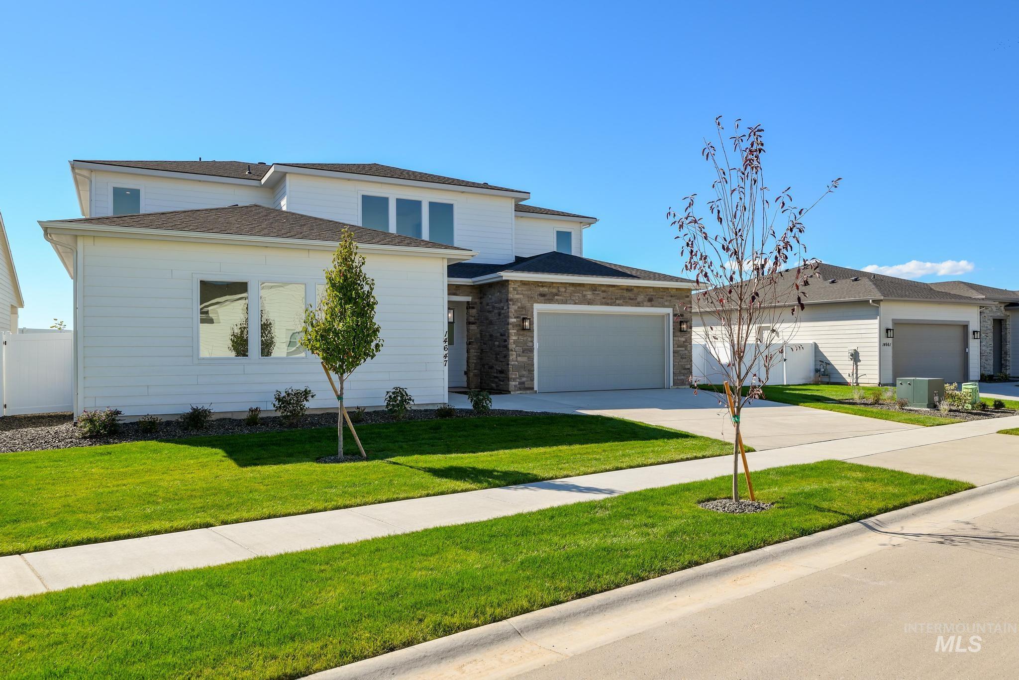 Prairie-style home featuring driveway, a garage, and brick siding