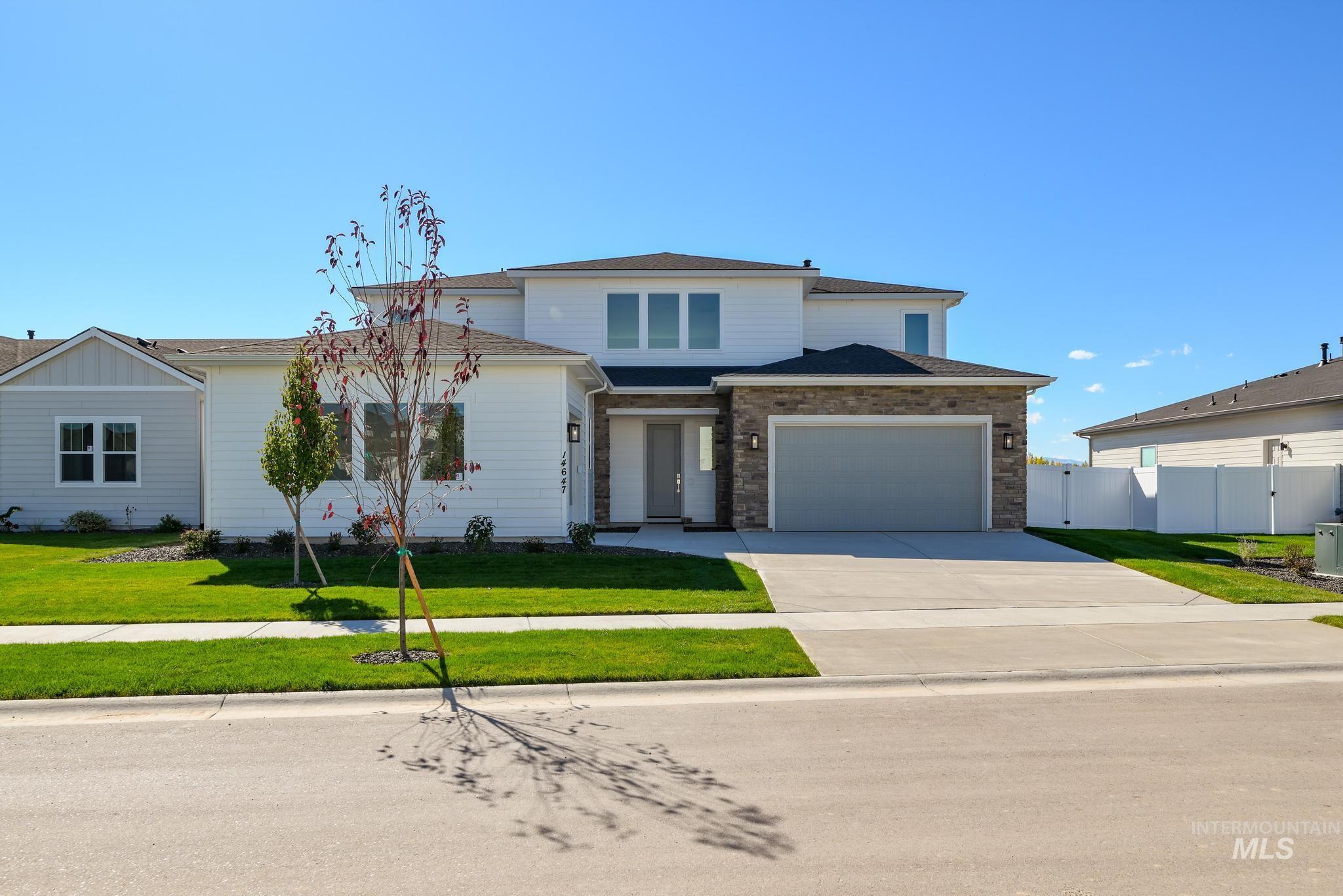 View of front of property with concrete driveway, brick siding, a shingled roof, and an attached garage