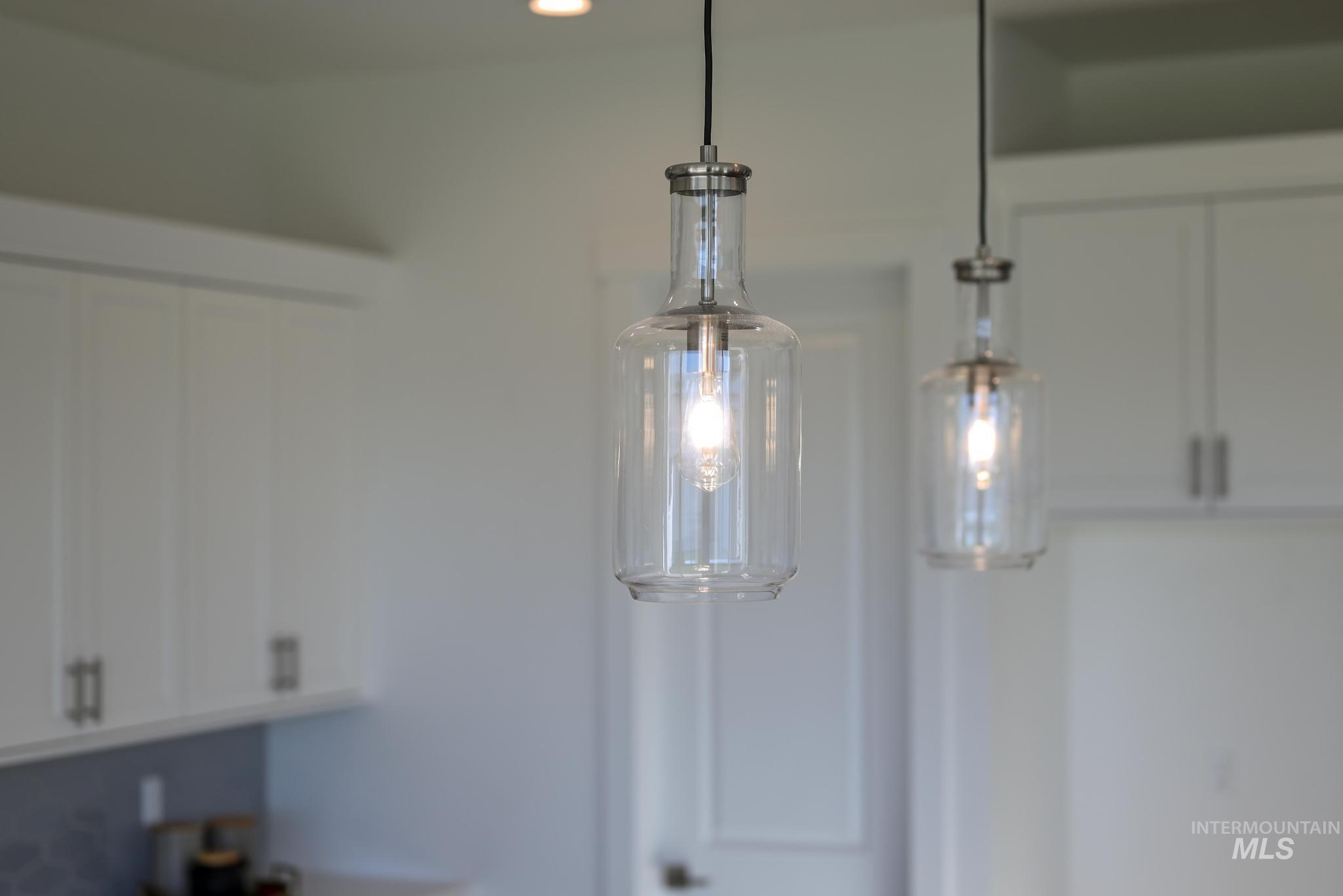 Kitchen view of white cabinets and pendant lighting