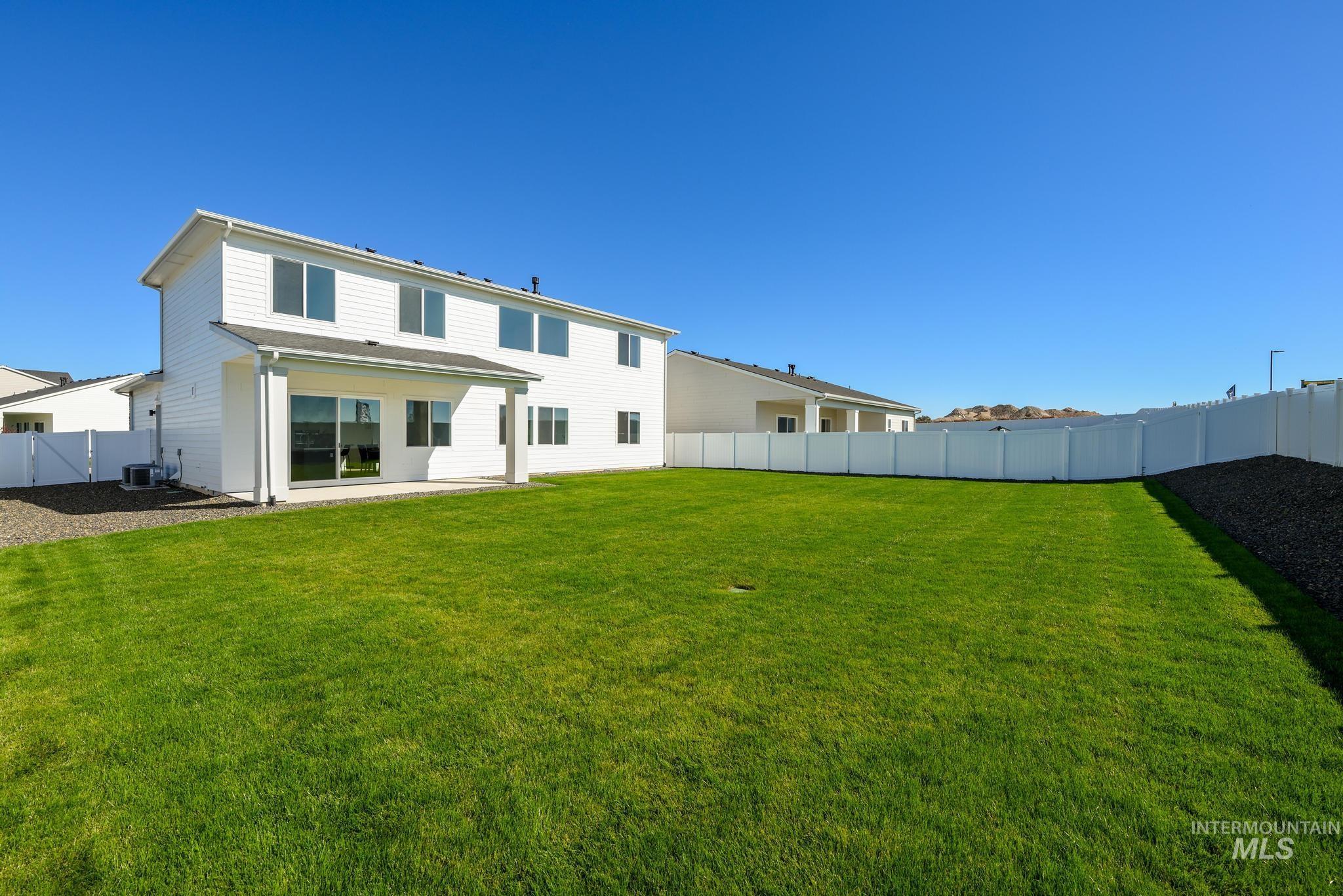 Rear view of house featuring a fenced backyard and a patio area